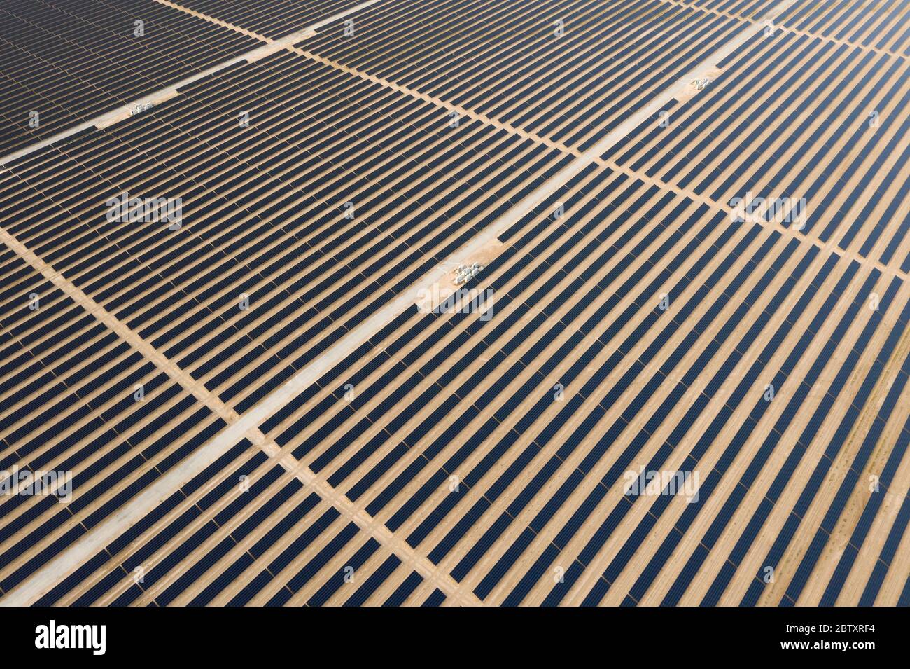 Vue aérienne d'un panneau solaire photovoltaïque et de transformateurs générant une énergie renouvelable durable dans une centrale électrique désertique. Banque D'Images