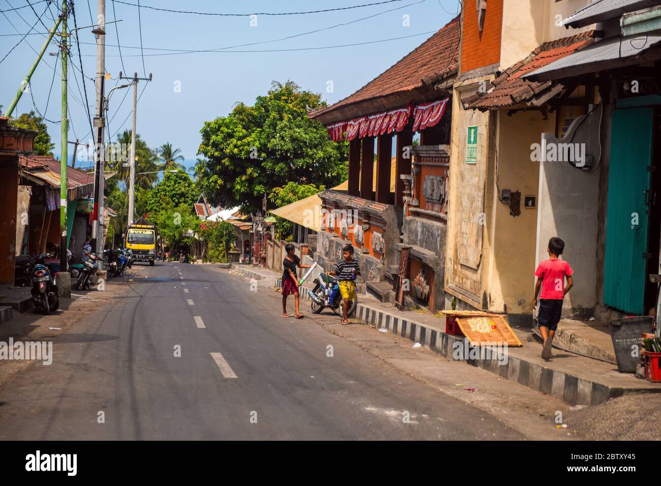 BALI, INDONÉSIE - 01 décembre 2019 : village traditionnel de la tribu balinaise. Des voitures et des motos longent la rue à Bali, en Indonésie Banque D'Images