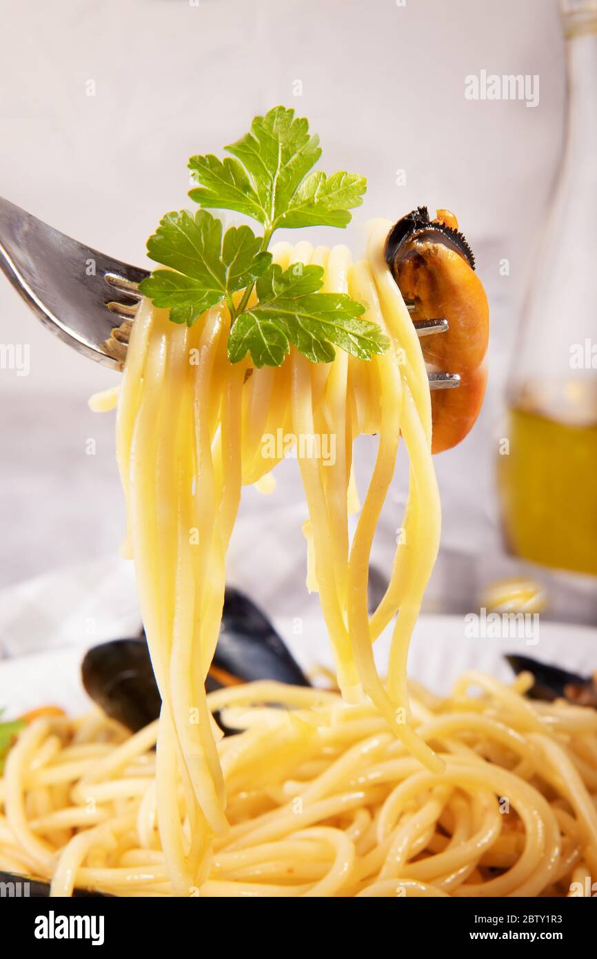 Spaghetti enveloppés dans une fourchette avec moule, gros plan de spaghetti  de pâtes italiennes populaires avec moule de Taranto Photo Stock - Alamy