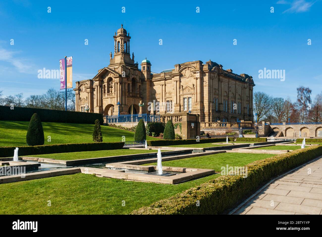 Extérieur de la galerie d'art civique de Cartwright Hall ensoleillée (grand bâtiment historique du musée) et fontaines de jardin aquatique Mughal - Lister Park, Bradford, Angleterre Banque D'Images