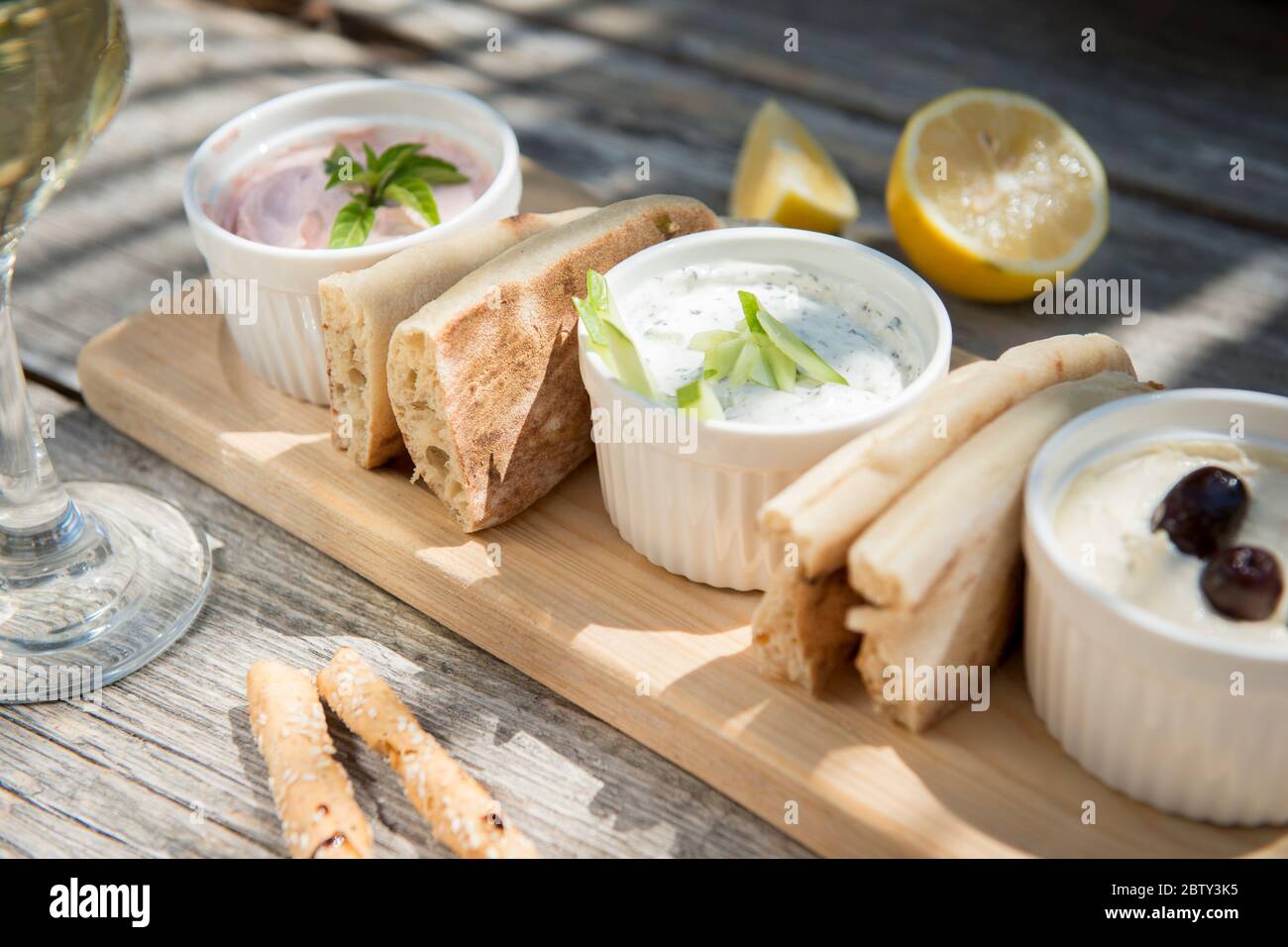 Meze dans un restaurant chypriote de Taramosalata, tzatziki, hummus, pain  pitta, citron et olives accompagné de vin blanc, Chypre, Méditerranée, Euro  Photo Stock - Alamy