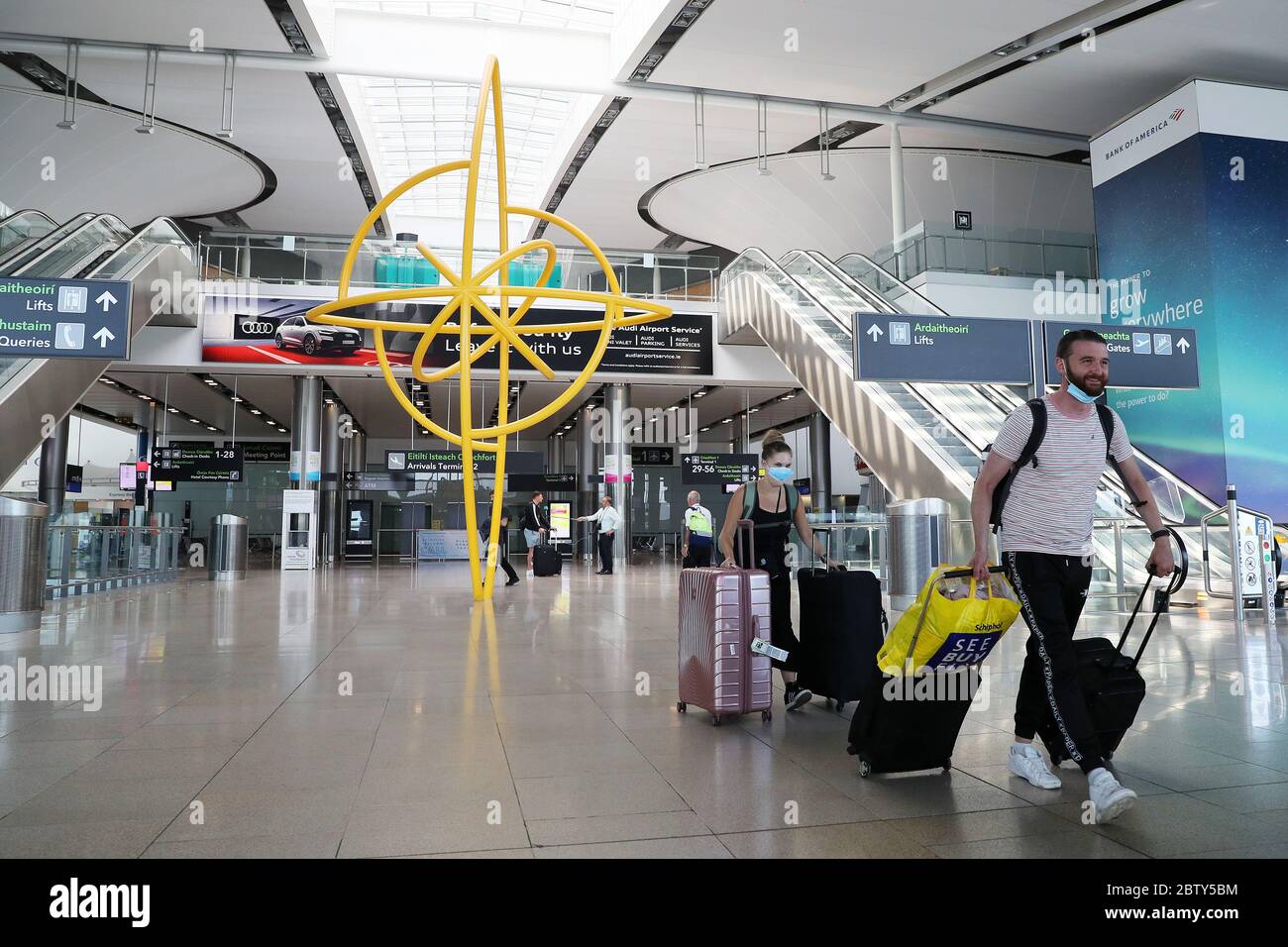 Les personnes portant un masque facial de protection traversent le terminal 2 de l'aéroport de Dublin. Les personnes arrivant en Irlande depuis l'étranger doivent avertir les autorités de l'endroit où elles seront auto-isolantes. Banque D'Images