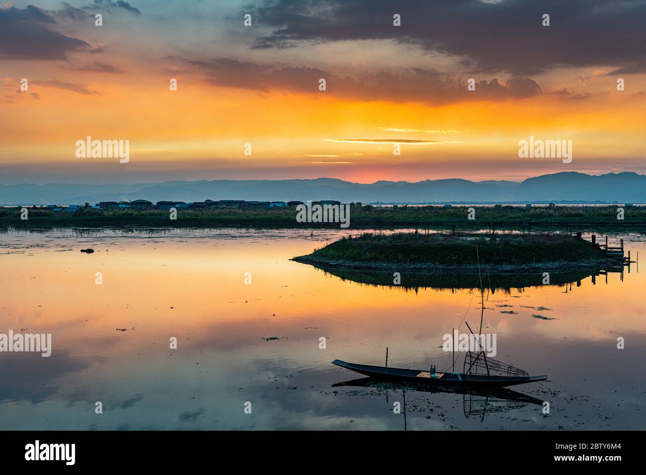 Nuages et bateau à rames traditionnel se reflétant dans l'eau au coucher du soleil, lac Inle, état Shan, Myanmar (Birmanie), Asie Banque D'Images