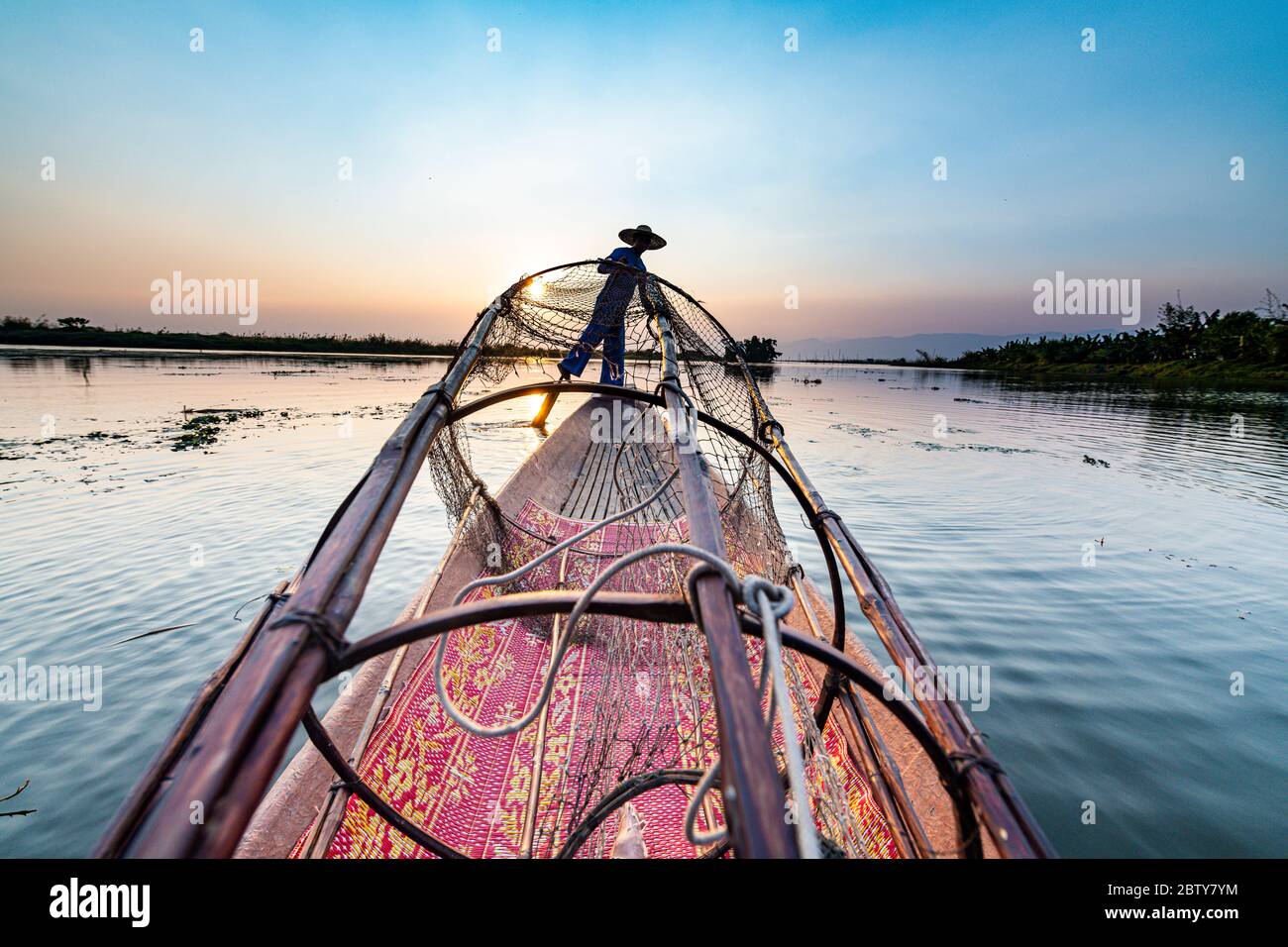 Pêcheur au lac Inle avec filet conique traditionnel Intha au coucher du soleil, filet de pêche, rames de jambe, peuple Intha, lac Inle, État Shan, Myanmar (Burm Banque D'Images