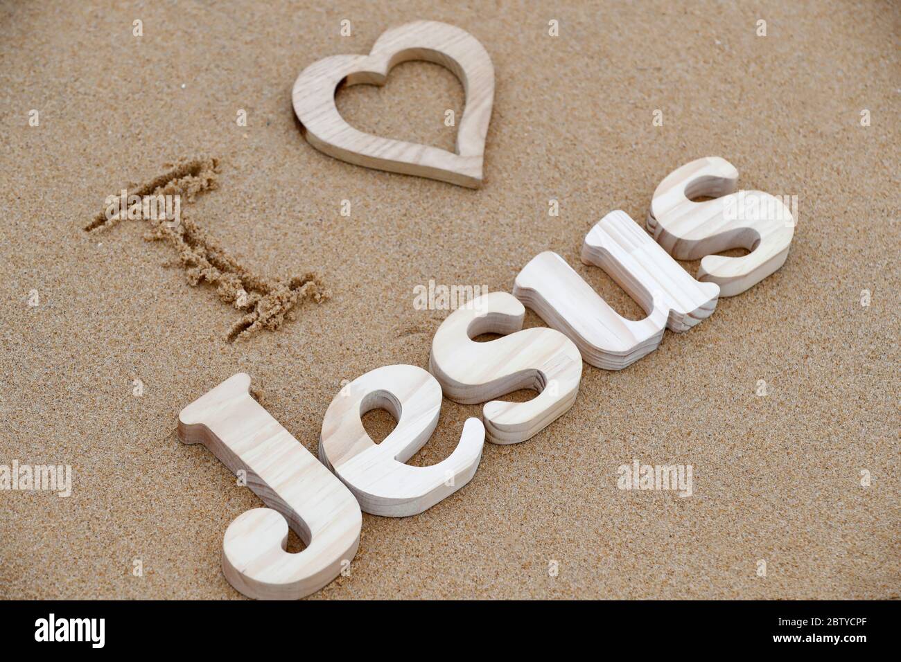Lettres en bois formant le mot JÉSUS avec coeur sur un fond de sable de plage, j'aime Jésus, symbole chrétien, Vietnam, Indochine, Asie du Sud-est, comme Banque D'Images