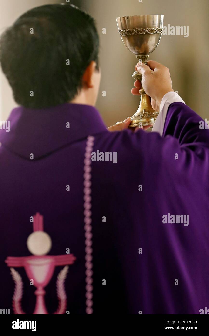 Prêtre portant un chasuble romain violet, Messe catholique, célébration eucharistique, élévation, Quy Nhon, Vietnam, Indochine, Asie du Sud-est, Asie Banque D'Images
