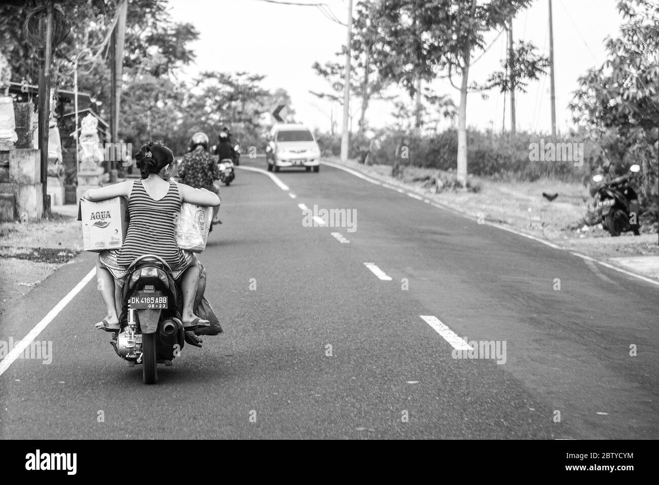 BALI, INDONÉSIE - 30 novembre 2019 : peuple balinais avec d'énormes bagages sur scooter. Trafic sur Bali. Indonésie Banque D'Images