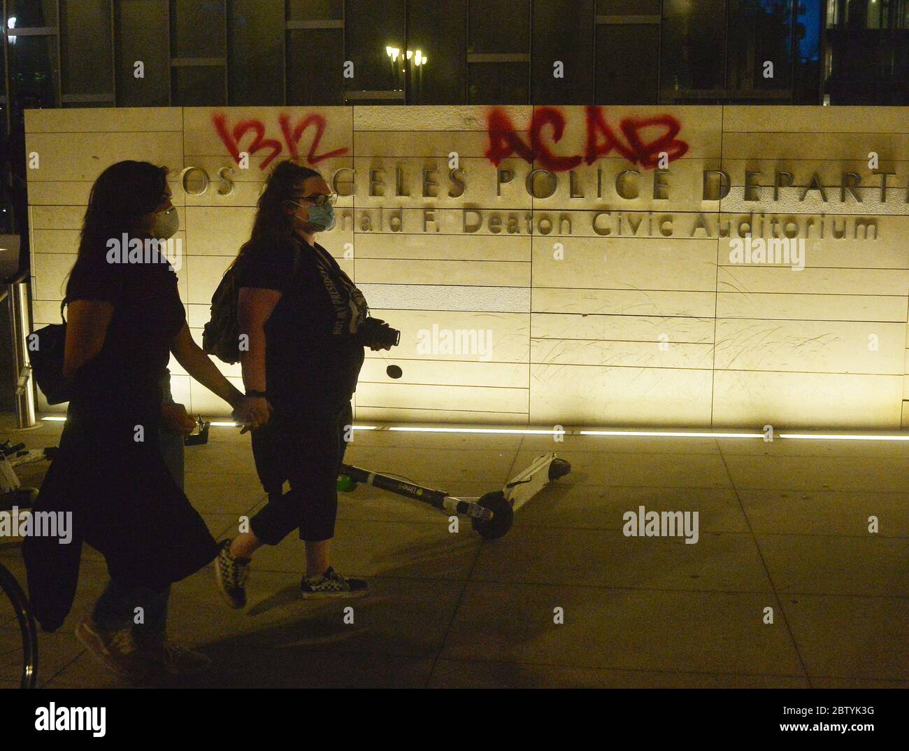 Los Angeles, États-Unis. 27 mai 2020. Deux femmes défilent devant le siège du département de police de Los Angeles, que quelqu'un a étiqueté avec des graffitis qui lisaient '1312 ACAB', un acronyme courant et son code numérique pour 'All COPS are Bastards', lors d'une manifestation dans le centre de Los Angeles, Californie, le mercredi 27 mai 2020. La manifestation, qui faisait partie d'une manifestation nationale, devait montrer l'indignation face à la mort de George Floyd, un homme noir tué lundi lorsqu'un policier blanc de Minneapolis l'a cloué au sol avec son genou. Photo de Jim Ruymen/UPI crédit: UPI/Alay Live News Banque D'Images