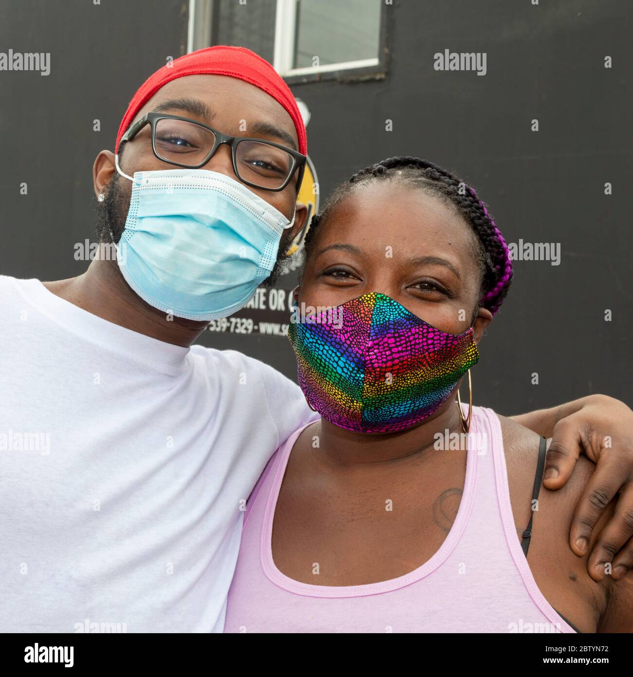 Detroit, Michigan - les bénévoles portant des masques de visage posent pour une photo tout en distribuant de la nourriture gratuite dans un quartier à faible revenu pendant le coronavirus pa Banque D'Images