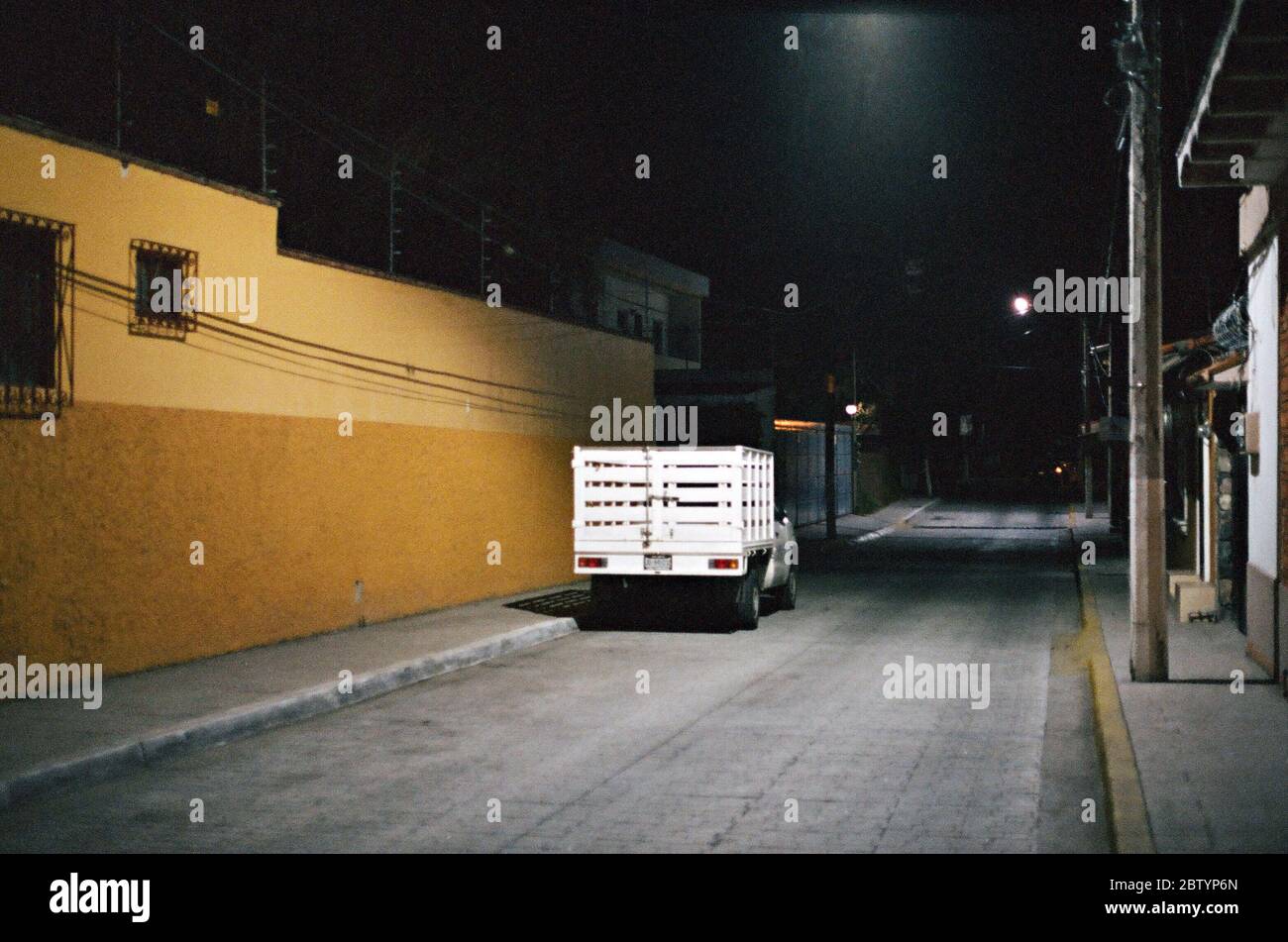 Camion blanc stationné dans une allée sombre la nuit à Chapala, au Mexique, éclairé par One Street Lamp Banque D'Images