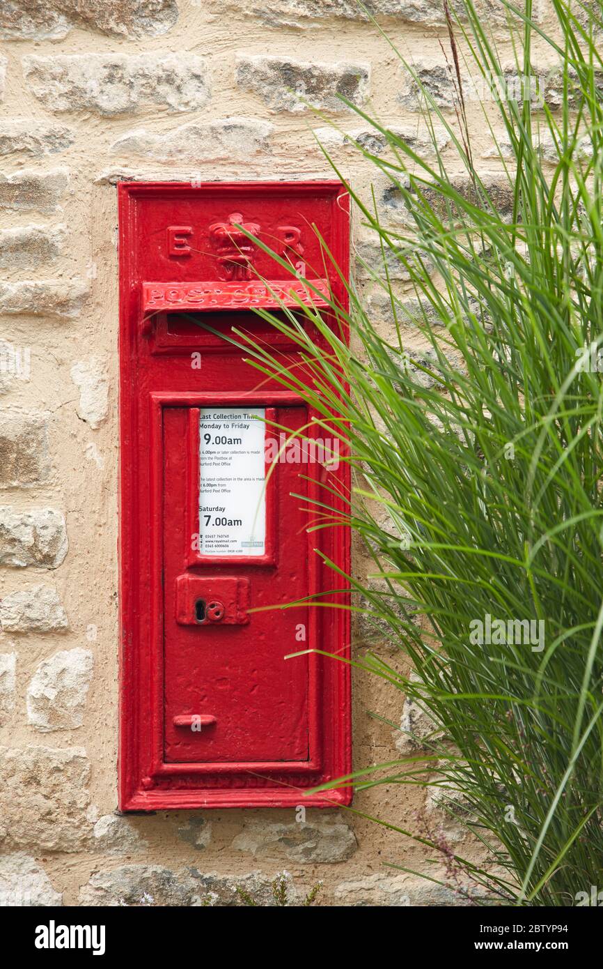 Boîte postale rouge traditionnelle sur mur en pierre, Burford, Cotswolds, Angleterre, Royaume-Uni Banque D'Images