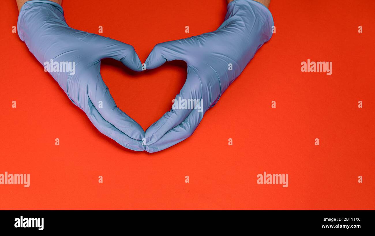 Mains avec des gants stériles en latex faisant un coeur isolé, contre COVID19 Banque D'Images