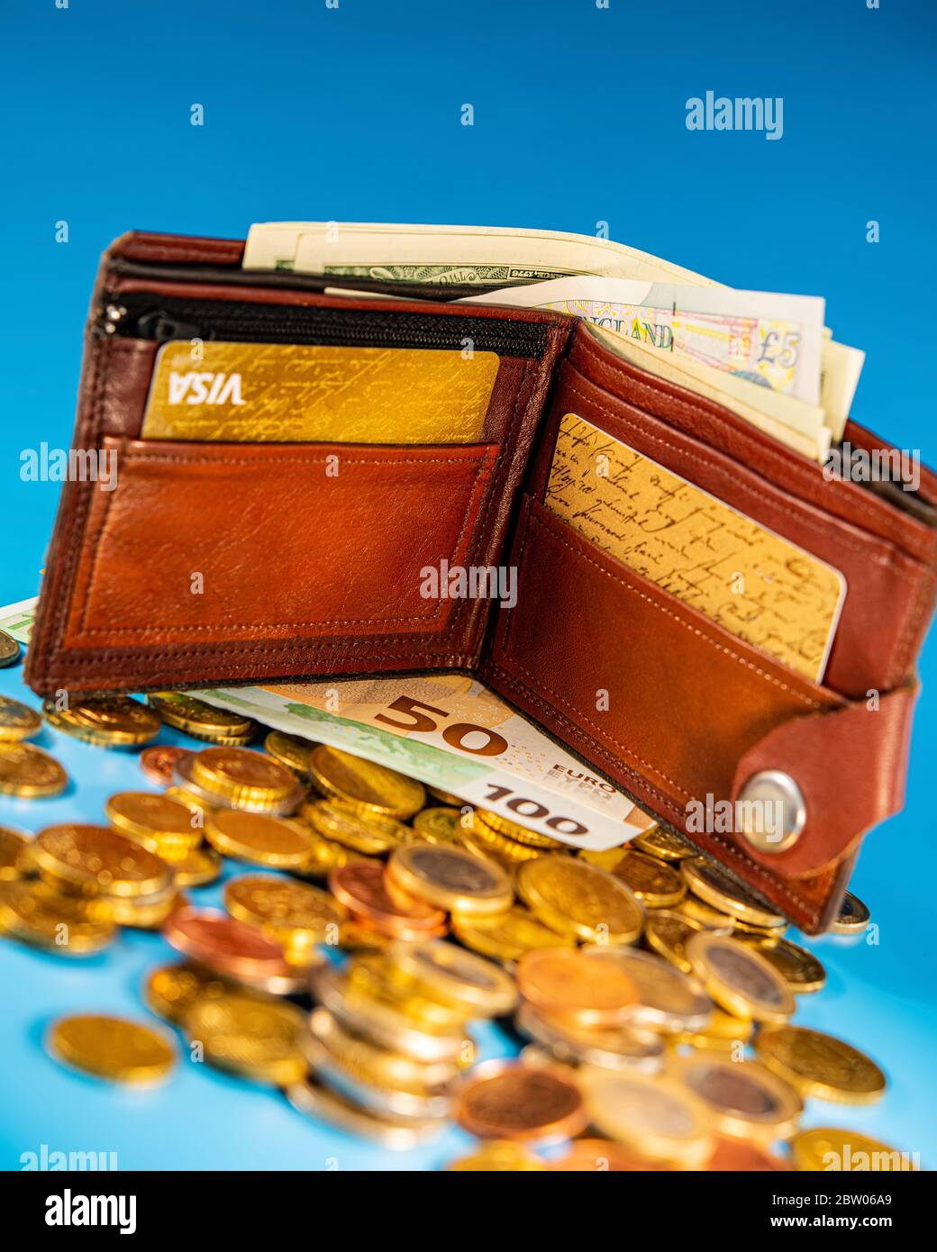 Porte-monnaie fait main avec billets en papier, cartes de crédit et pièces  sur fond bleu. Concept d'entreprise Photo Stock - Alamy