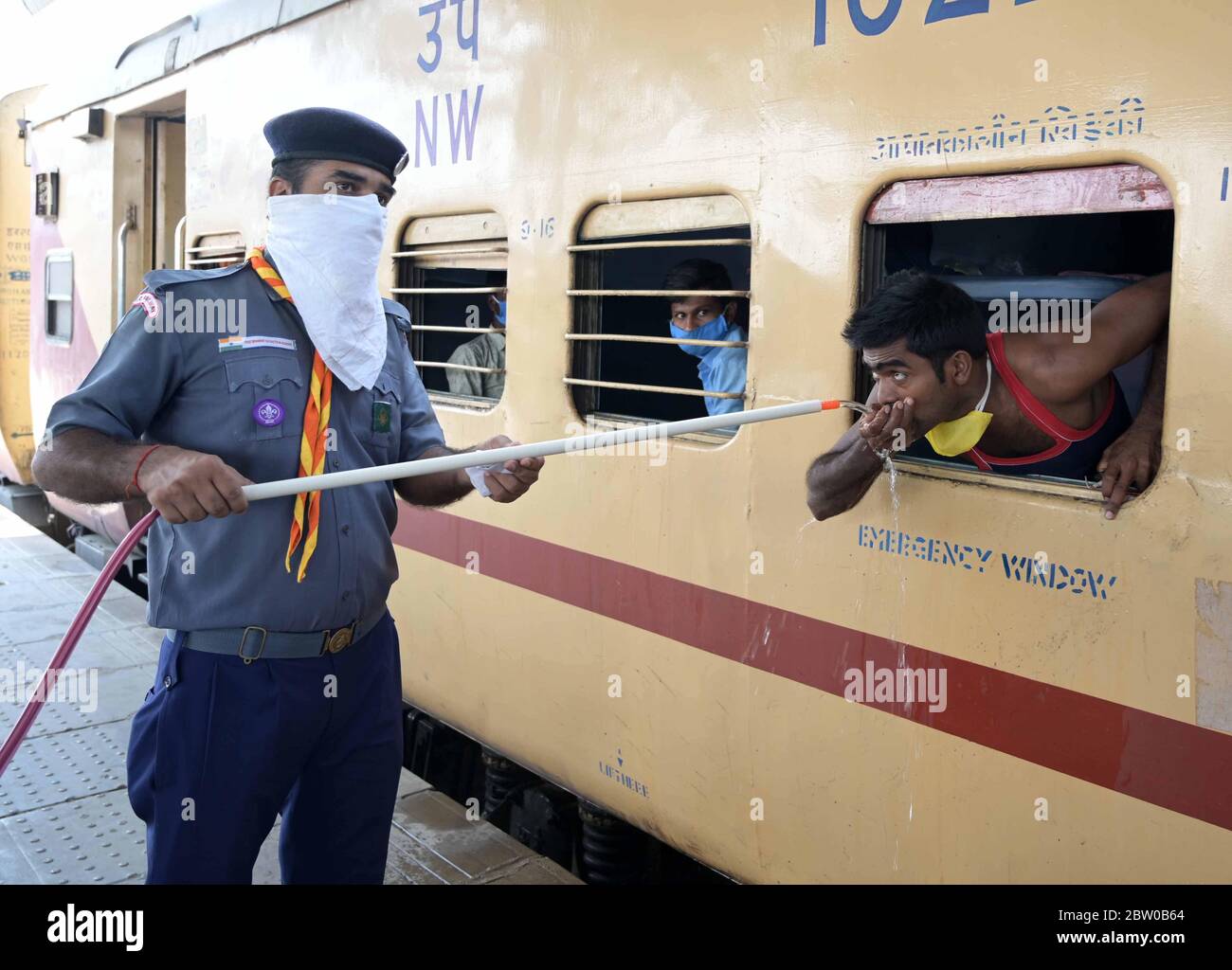 Prayagraj, Uttar Pradesh, Inde. 28 mai 2020. Prayagraj : un volontaire fournit de l'eau aux voyageurs migrants de Mumbai lorsqu'ils voyagent en train spécial à la jonction de Prayagraj pendant le lockdown national de la COVID-19. Credit: Prabhat Kumar Verma/ZUMA Wire/Alamy Live News Banque D'Images