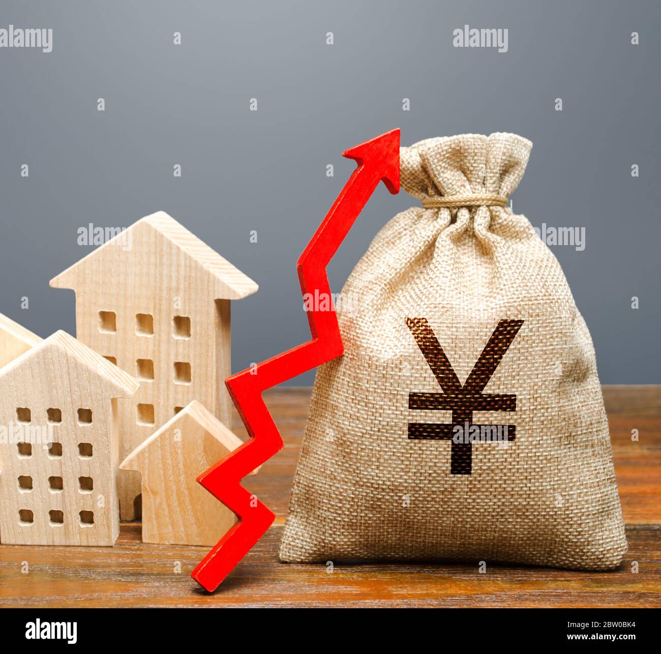 Maisons en bois et un sac d'argent avec une flèche vers le haut. Le concept d'augmentation du coût du logement. La croissance des taux de loyer et d'hypothèque. Augmentation des loyers, p Banque D'Images