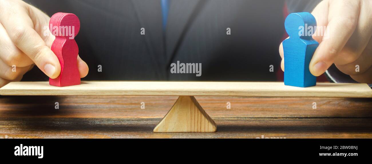 La figure d'un homme et une femme sur les balances. Écart de rémunération entre les sexes. L'égalité, l'inégalité. La notion de divorce et de partage des biens. La résolution de famille dis Banque D'Images