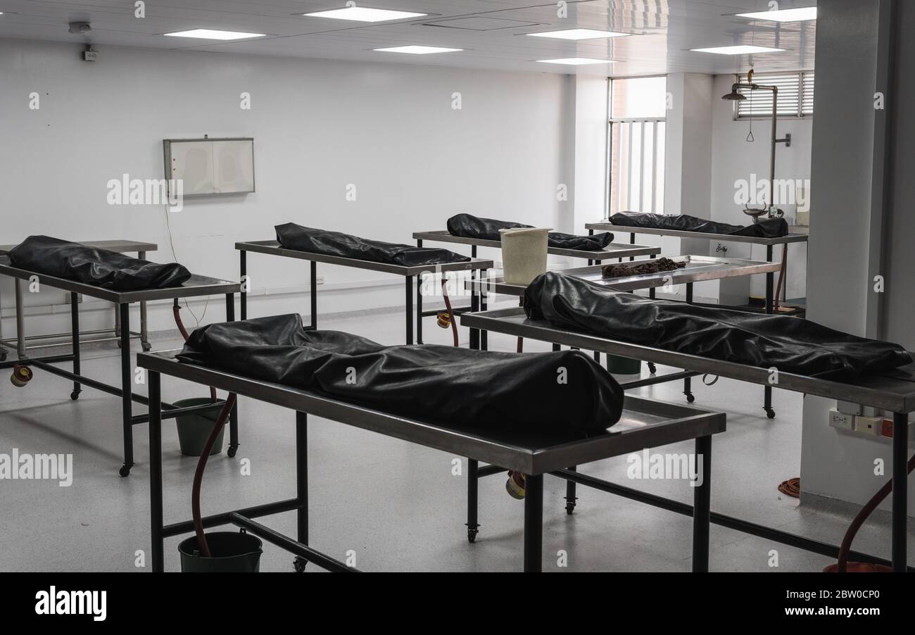 Cadavres humains couverts sur des tables dans une morgue/morgue en attente d'identification, d'autopsie, d'enterrement ou de crémation. Pris en Arménie, Colombie. Banque D'Images