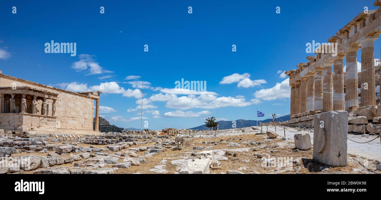 Acropole d'Athènes, Grèce. Parthénon temple et une partie d'Erechtheum, drapeau grec agitant sur fond bleu ciel, printemps ensoleillé jour. Banque D'Images