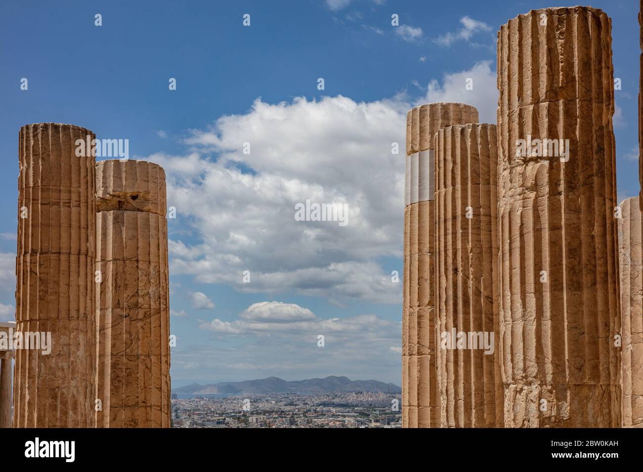 Athènes Acropole, site touristique de la Grèce. Colonnes grecques anciennes piliers à la porte d'entrée de Propylaea, vue sur la ville et ciel bleu nuageux. Banque D'Images