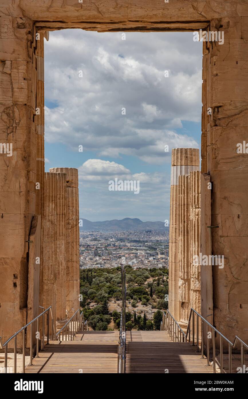 Athènes Acropole, site touristique de la Grèce. En quittant l'ancienne Grèce Propylaea, vue sur la ville depuis une ouverture avec piliers de style ionique, photo verticale, bleu nuageux sk Banque D'Images