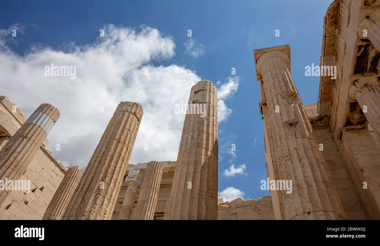 Athènes Acropole, site touristique de la Grèce. Vue à angle bas des piliers grecs anciens à la porte d'entrée de Propylaea, ciel bleu nuageux. Banque D'Images