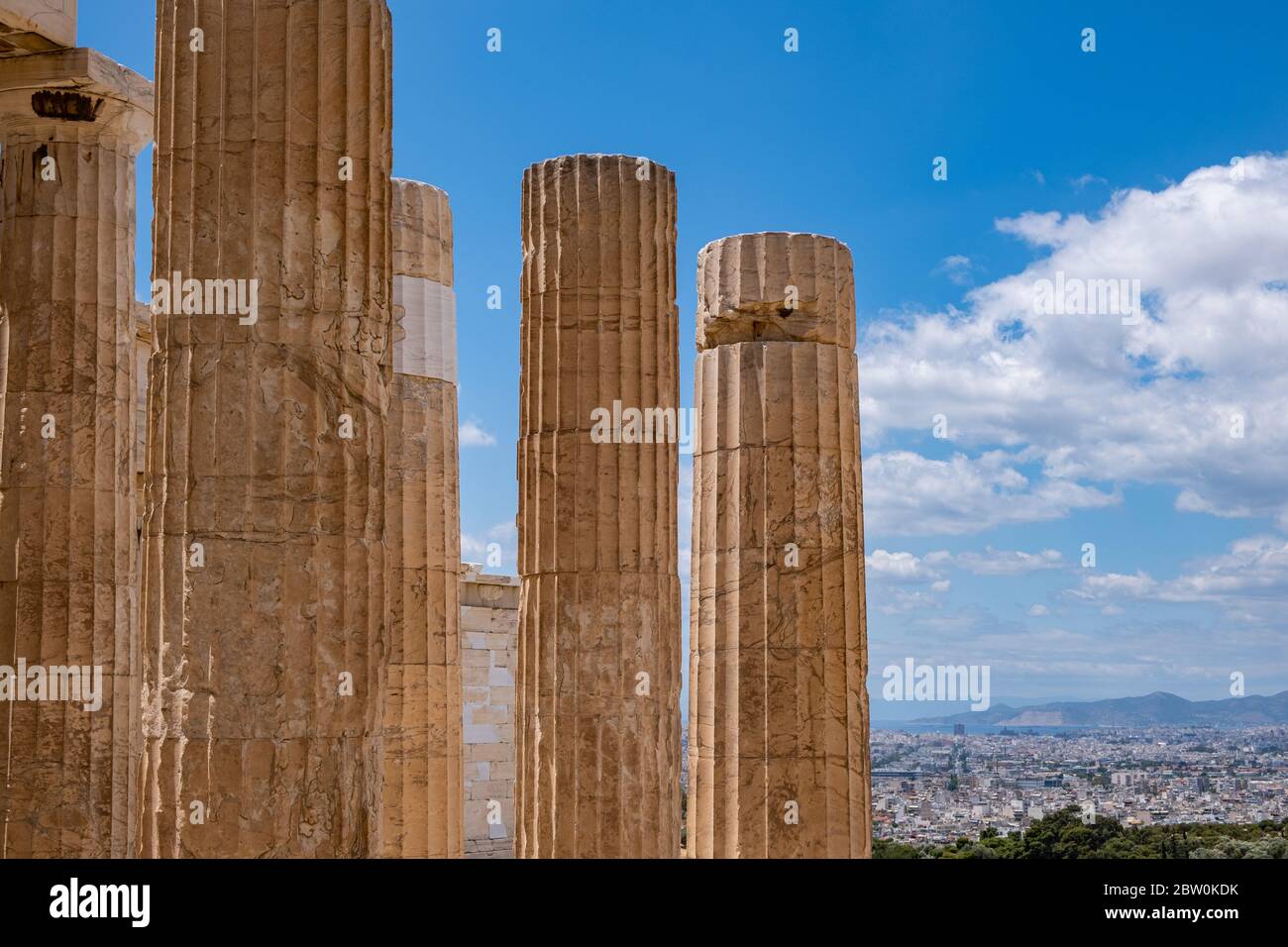 Athènes Acropole, site touristique de la Grèce. Colonnes grecques anciennes piliers à la porte d'entrée de Propylaea, vue sur la ville et ciel bleu nuageux. Banque D'Images