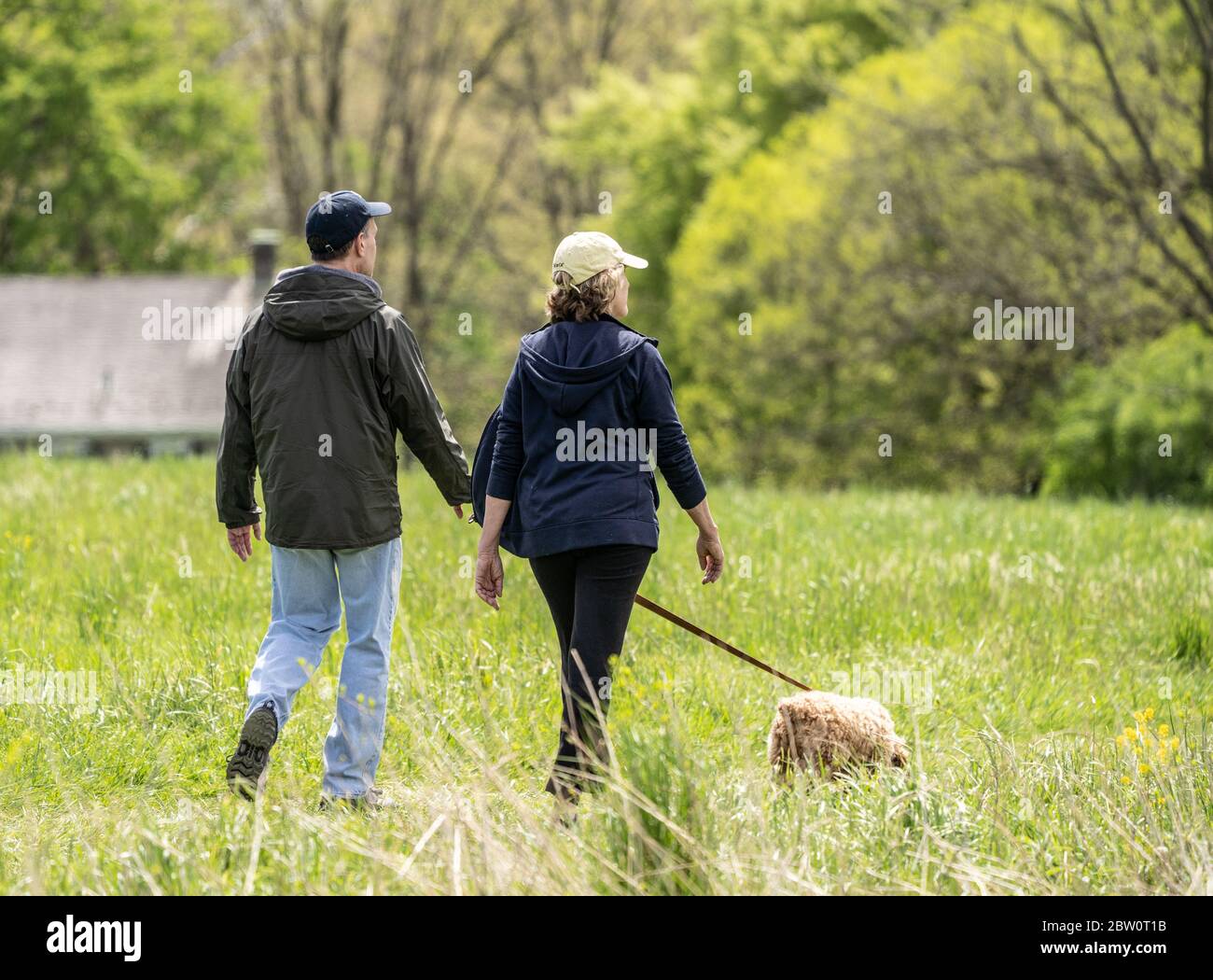 Comté de Berks, Pennsylvanie - 5 mai 2020 : un couple senior prend son chien pour une promenade dans le parc au printemps après-midi. Banque D'Images