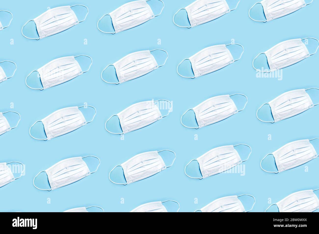 Motif du masque de protection médicale blanc sur fond bleu. Banque D'Images