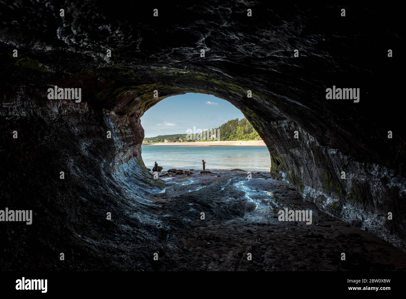 St. Martins, NB, Canada - 28 juillet 2019 : vue de l'intérieur d'une grotte marine à St. Martins. Les gens à l'entrée montrent la taille de la grotte. La grotte Banque D'Images