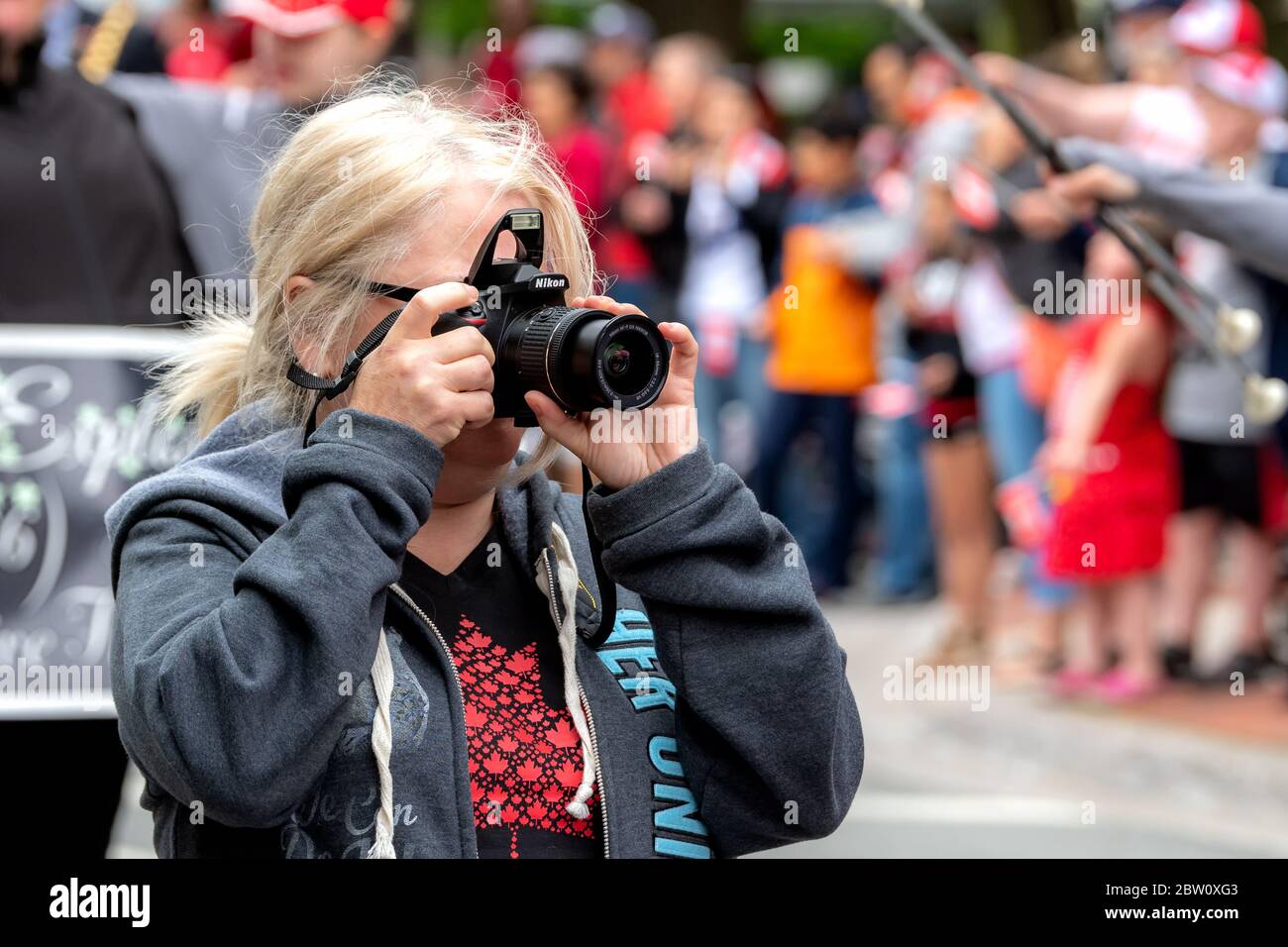 Saint John, Nouveau-Brunswick, Canada - le 1er juillet 2019 : un photographe amateur prend une photo au défilé de la fête du Canada à l'aide d'un appareil photo Nikon. Banque D'Images