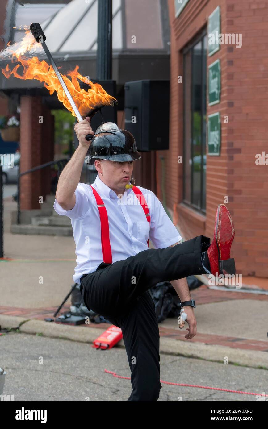 Saint John, Nouveau-Brunswick, Canada - le 13 juillet 2017 : un pompier portant un casque noir brûlant porte une torche allumée pendant qu'il marche à l'oie. Banque D'Images