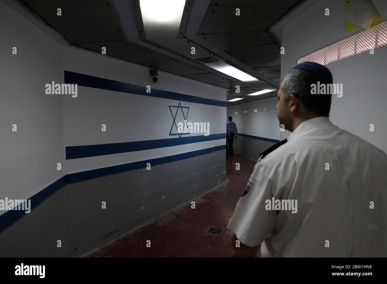 Officier du service pénitentiaire d'Israël communément connu en Israël par son acronyme Shabas ou ISP en anglais marchant le long d'un couloir peint avec le drapeau israélien à l'intérieur de la prison d'Eshel près de Beersheba en Israël Banque D'Images