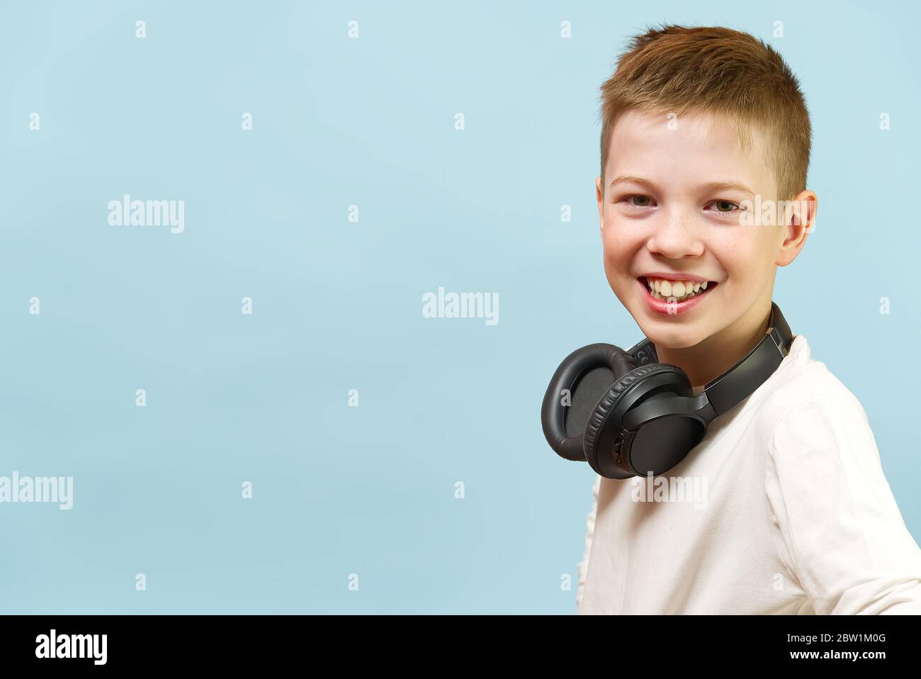 Jeune garçon souriant sur fond bleu dans un casque. Concept de radio pour  bébé, dj, chanteur ou karaoké. Bonheur être de la musique partout Photo  Stock - Alamy