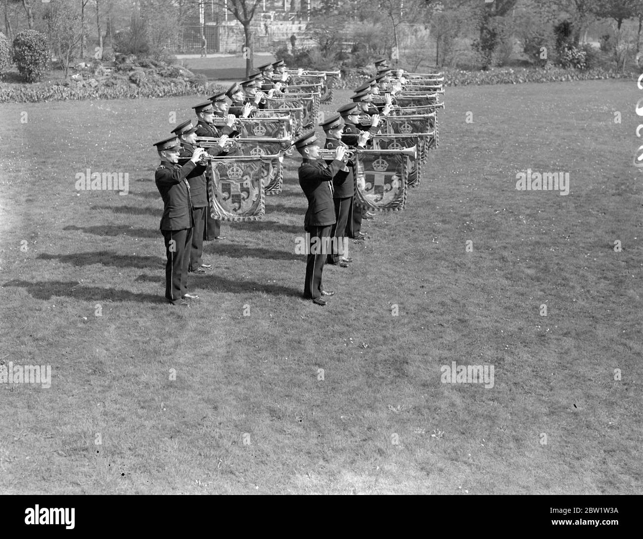 Couronnement. Les trompettistes s'exercent à Kneller Hall. Avec leurs trompettes accrochées de bannières colorées, 50 trompettistes de l'École militaire royale de musique pratique à Kneller Hall, Twickenham, les fanfares qu'ils sonneront au Coronation à l'abbaye de Westminster. Spectacles de photos : un trompettiste qui sonne le fanfare du Couronnement à Kneller Hall. 19 avril 1937 Banque D'Images