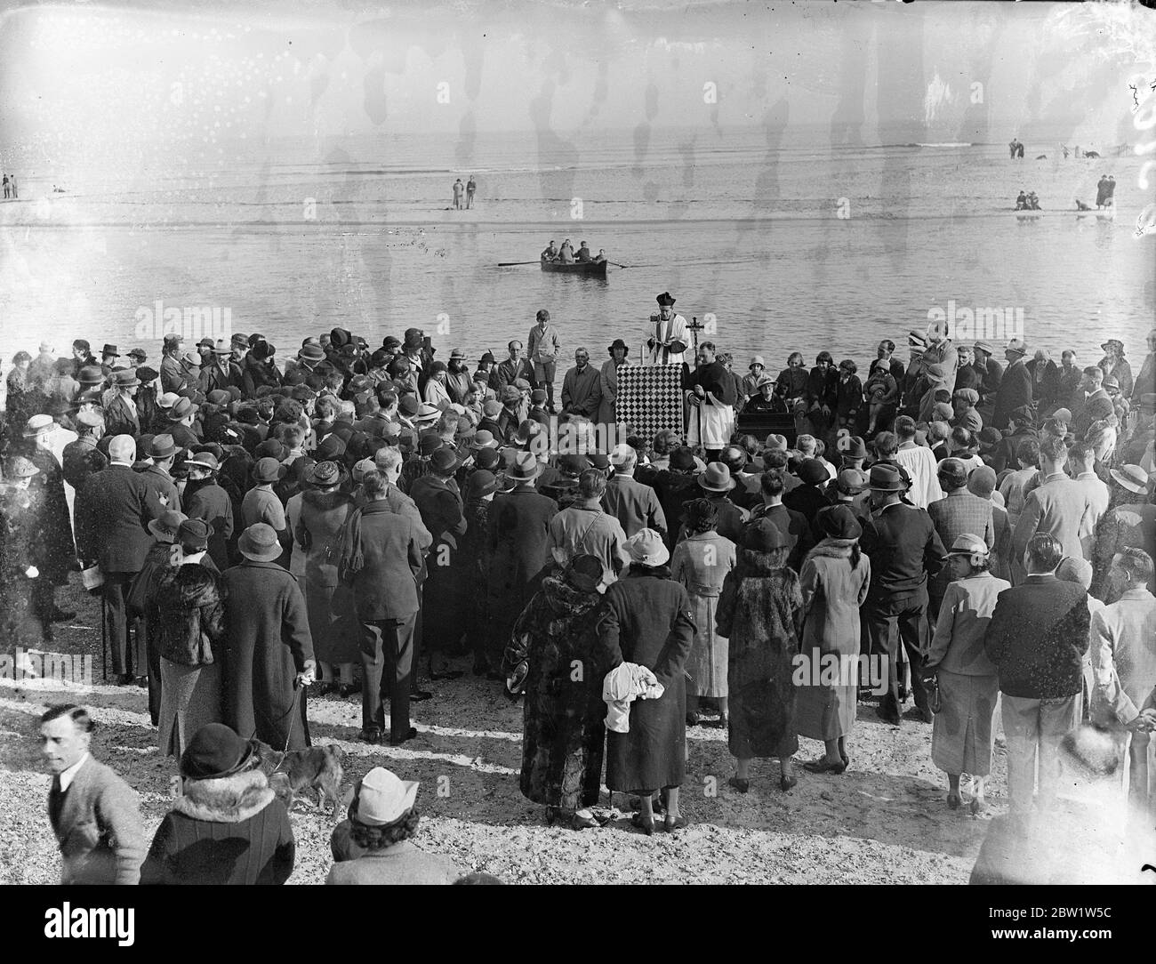 Bénédiction des eaux d'un bateau à Mudford . Après un service à l'église All Saints , le Rév Eric Dixon s'embarque à Haven Quay et a exécuté la cérémonie de Bénédiction des eaux à Mudeford , près de Christchurch , Hampshire . Des prières ont été offertes aux pêcheurs de saumon dont les moyens de subsistance dépendent de la pêche . Photos , vue générale à Mudeford alors que le Rév Eric Dixon s'embarque pour bénir les eaux . 4 avril 1937 Banque D'Images
