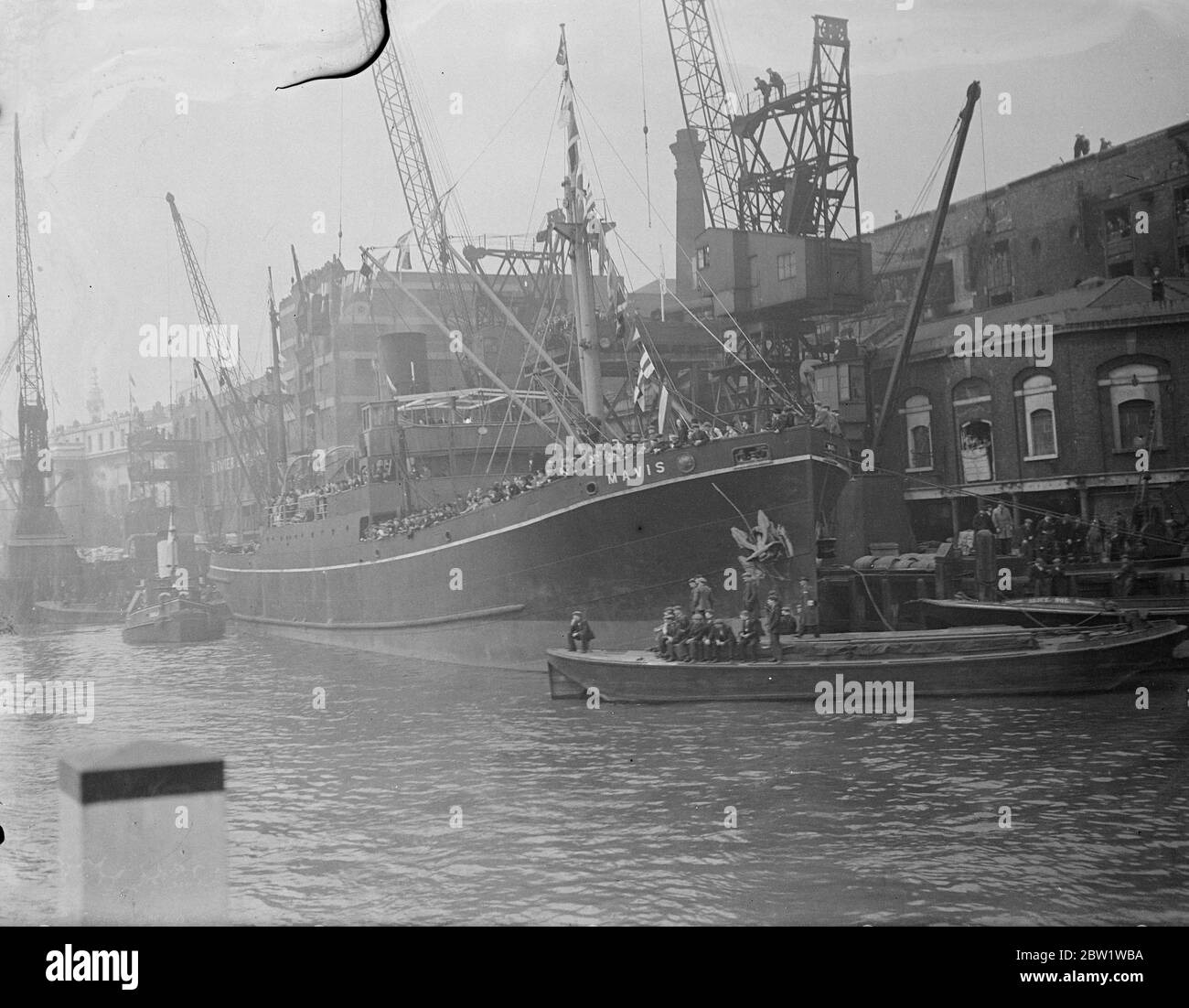 Bateau comme grand-acronyme pour la procession royale par Pool of London. Le roi et la reine partirent dans la barge royale de Westminster à Greenwich pour ouvrir le nouveau Musée maritime national. Photos: Le S. S. Mavis et d'autres navires bondés avec des spectateurs dans la piscine de Londres. Même des grues étaient utilisées comme tribunes. 27 avril 1937 Banque D'Images
