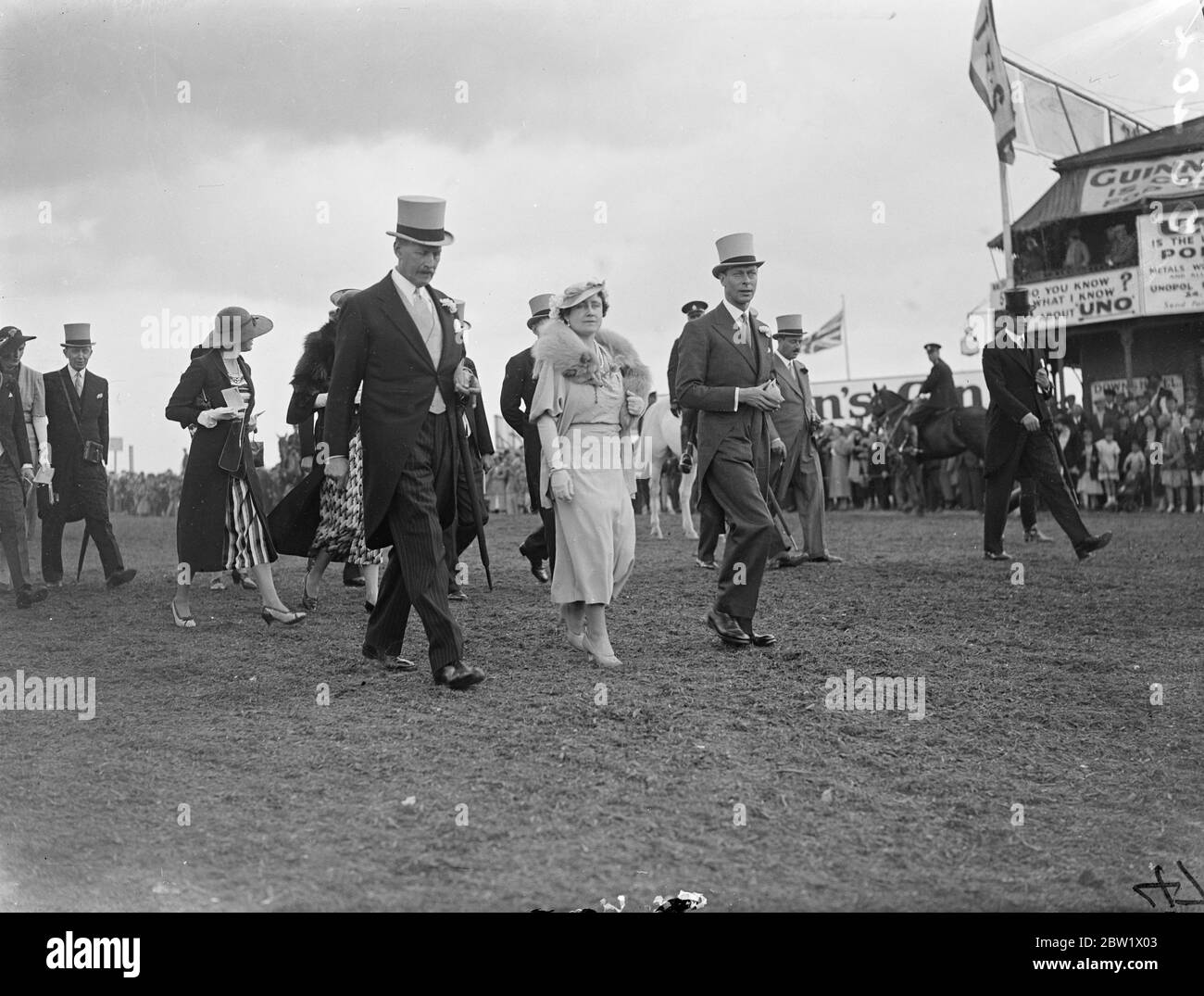 King et Queen marchaient jusqu'au paddock à Epsom le jour de Oaks. Le Roi et la Reine, en payant une deuxième visite en trois jours, ils peuvent marcher sur le parcours d'Epsom jusqu'au paddock avant le début des Oaks. Spectacles photo, le roi et la reine marchant jusqu'au paddock à Epsom. 4 juin 1937 Banque D'Images