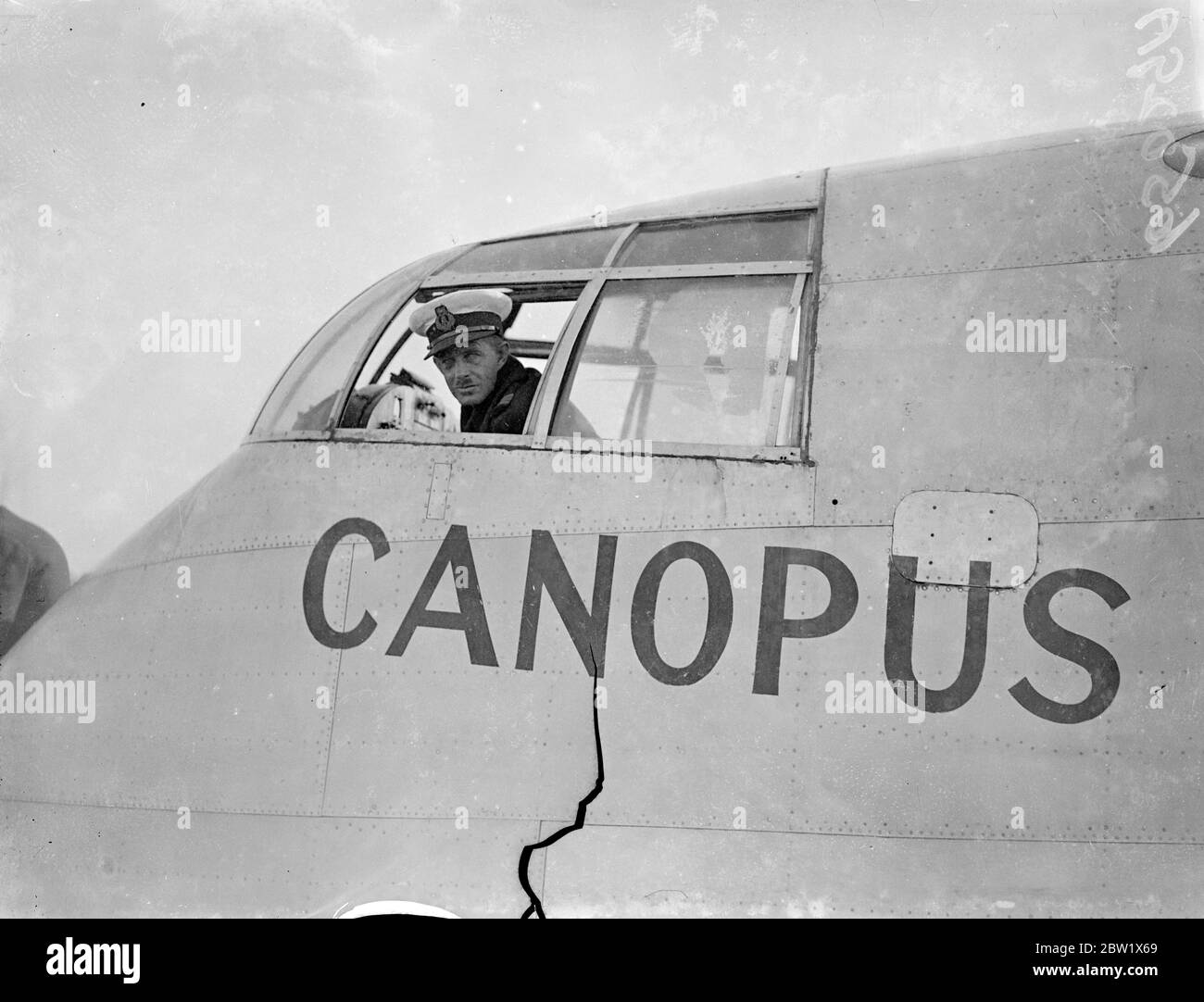 Commandant du bateau volant qui est descendu en Irak le capitaine Ernest Henry 'Tich' Attwood était à la tête du bateau volant Imperial Airways Calpurnia, qui a fait un atterrissage forcé dans le coin sud-ouest du lac Habbaniya, en Irak, tout en volant du courrier spécial d'Alexandrie à Bagdad. La machine était située par des avions de la RAF et trois membres de l'équipage étaient visibles. Le bateau volant semblait endommagé. Expositions de photos, le capitaine Ernest Henry Attwood vu dans le poste de pilotage de l'Empire Flying Boat 'Canopus'(G-ADHL). 28 novembre 1938 Banque D'Images