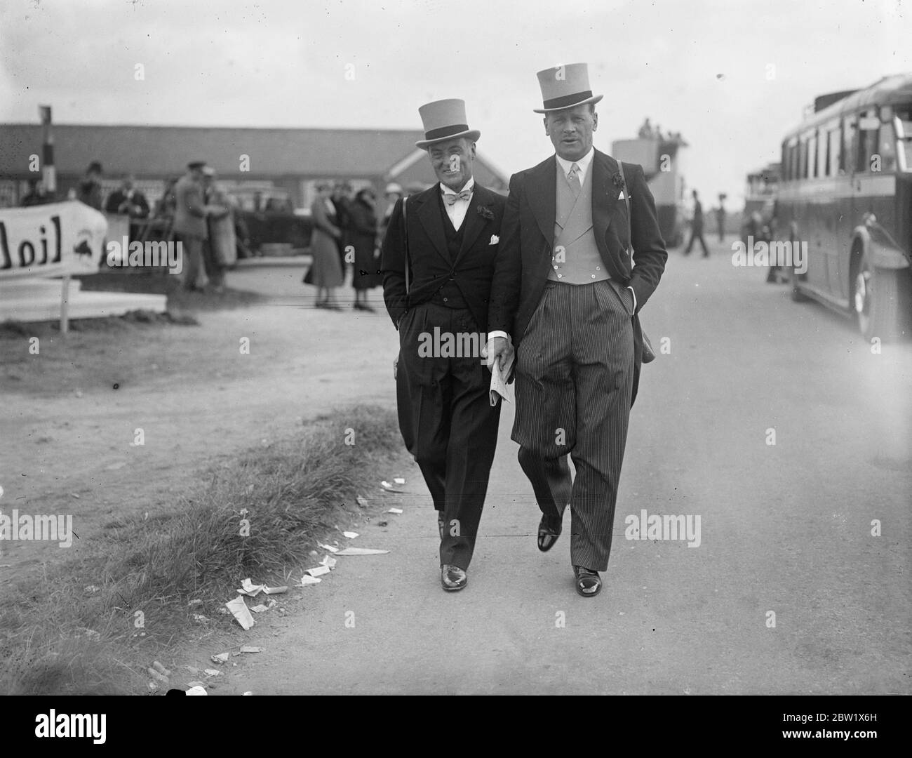 Sir Malcolm Campbell au Derby. Sir Malcolm Campbell (à gauche), l'homme le plus rapide à roues, marchant avec un ami sur le parcours d'Epsom, où il regardait les chevaux les plus rapides se battre pour les honneurs de Derby. 2 juin 1937 Banque D'Images