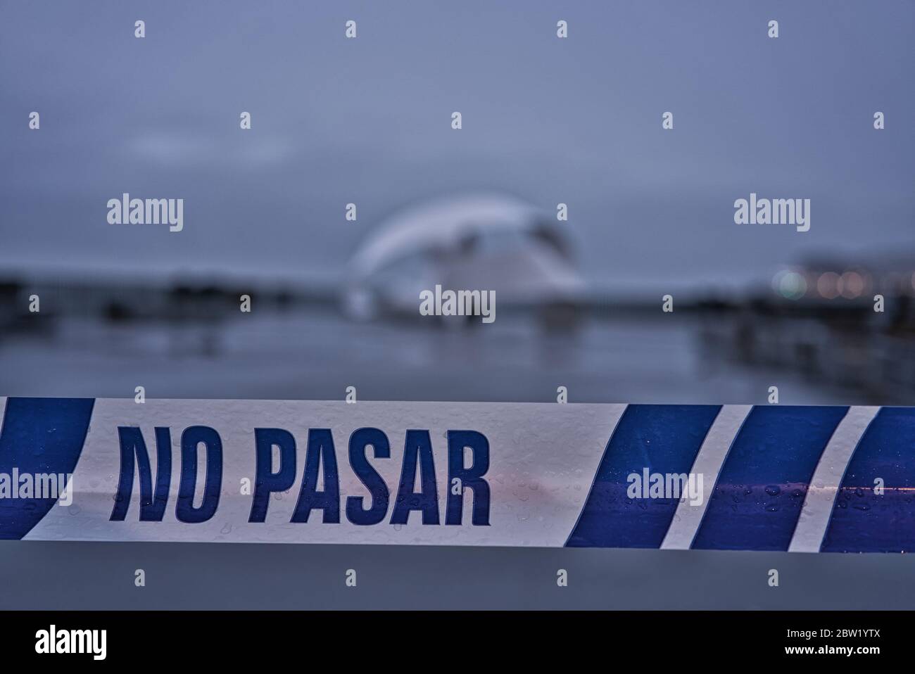 Avant-plan extérieur avertissement de ne pas passer un objet hors foyer en arrière-plan sur une journée de vents forts, gris et tristes. Ruban plastique blanc et bleu Banque D'Images