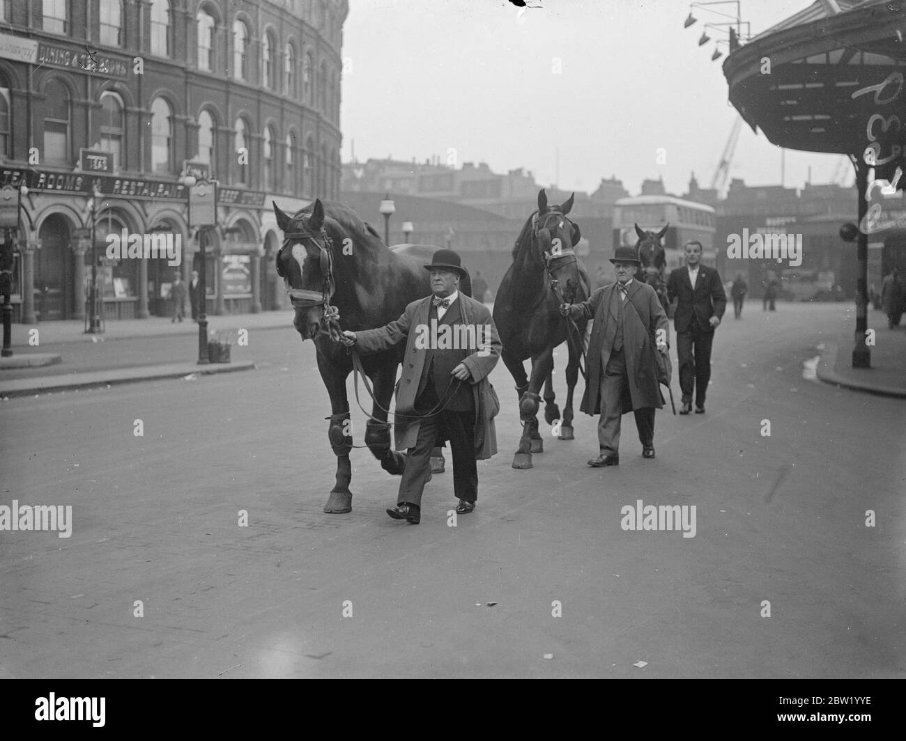 Le cachman et les chevaux du Seigneur Maire partent pour Paris. M. William Grainger, le cachman du Lord Mayor a quitté le London Bridge pour Paris avec l'équipe de chevaux pour conduire le Lord Mayor de Londres dans l'État à travers les rues de Paris pour ouvrir le pavillon britannique à l'exposition de Paris. Expositions de photos, M. William Grainger avec les chevaux du Lord Mayor à la gare de London Bridge avant le départ. 17 juin 1937 Banque D'Images