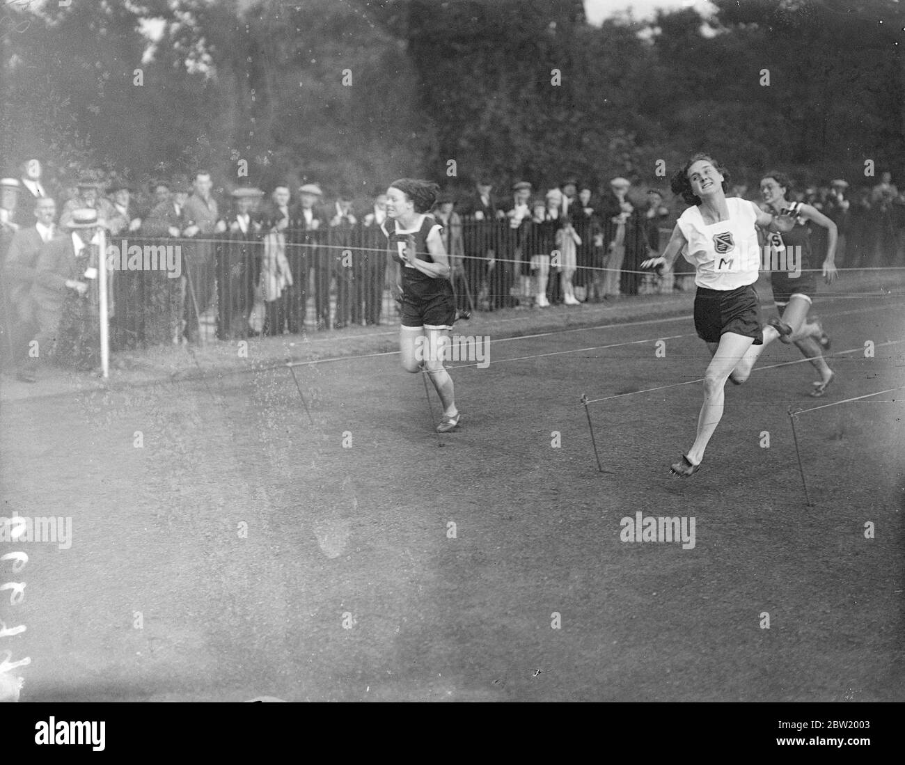 La Surrey County Women's amateur Athletic Association a rencontré la Middlesex County Women's Athletic Association dans un match intercomté à Battersea Park, Londres. Mlle D. Cook (Middlesex) a remporté la course de 100 mètres dans ce style spectaculaire de Miss B. Burke (Surrey), la championne sud-africaine. 20 juillet 1937 Banque D'Images