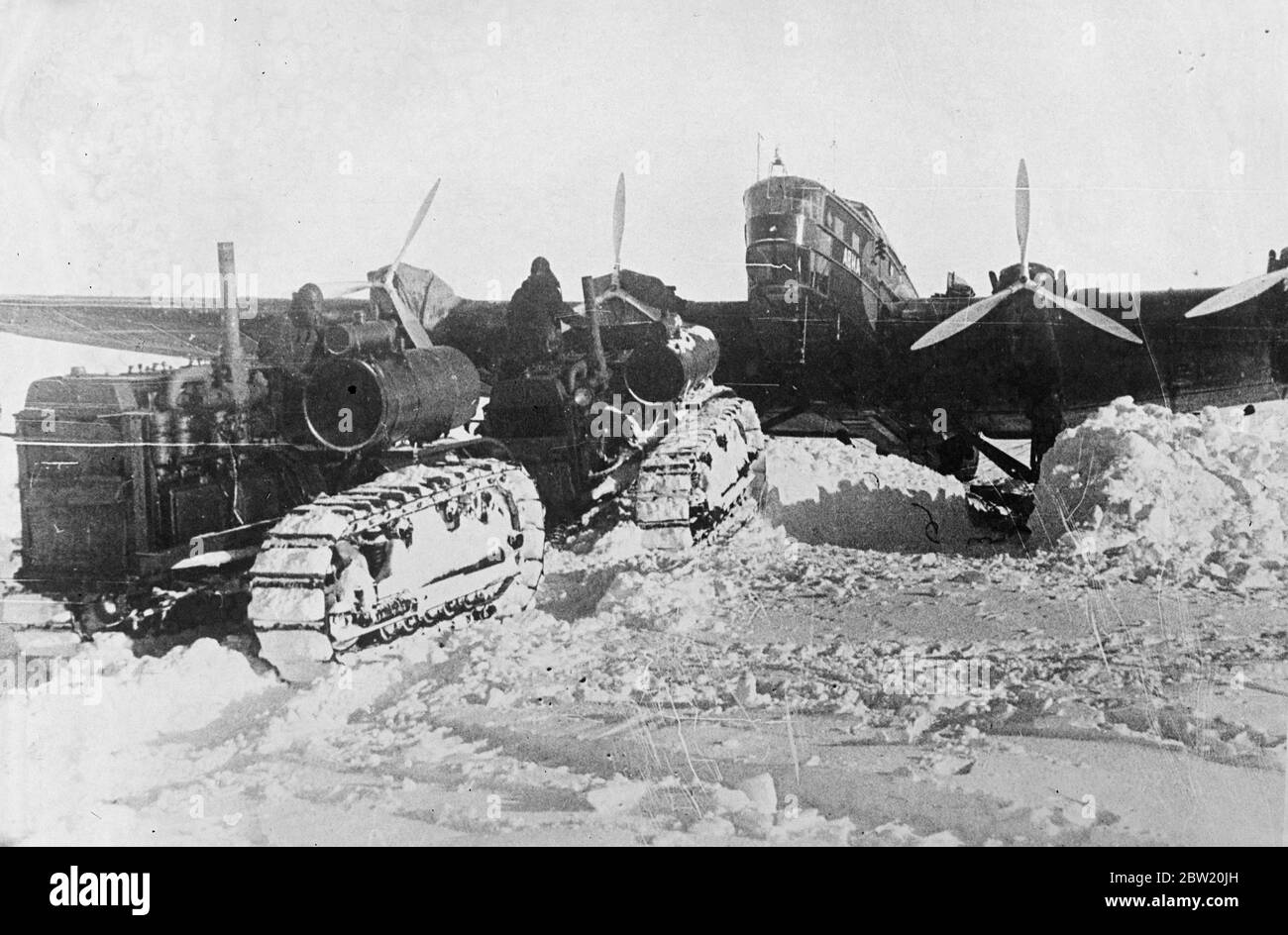 Ces photos, du pôle Nord, ont été prises par avion à Moscou et de là à Londres. L'expédition scientifique soviétique dirigée par le professeur Otto Schmidt a réussi à établir un village scientifique sur une banquise dans la nature gelée à partir de laquelle des informations scientifiques précieuses et des bulletins météorologiques réguliers sont maintenant envoyés par radio pour la première fois dans l'histoire. Tracteurs utilisés par l'expédition devant l'un des avions géants. 30 juin 1937 Banque D'Images Ces photos, du pôle Nord, ont été prises par avion à Moscou et de là à Londres. L'expédition scientifique soviétique dirigée par le professeur Otto Schmidt a réussi à établir un village scientifique sur une banquise dans la nature gelée à partir de laquelle des informations scientifiques précieuses et des bulletins météorologiques réguliers sont maintenant envoyés par radio pour la première fois dans l'histoire. Tracteurs utilisés par l'expédition devant l'un des avions géants. 30 juin 1937 Banque D'Images