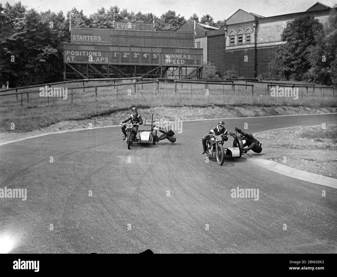 Les motocyclistes ont eu une dernière pratique sur le circuit de course de Crystal Palace Road pour la réunion du Grand Prix de Londres aujourd'hui (samedi). John Surtees (23) et T. F. Pullin (28) se battent pour la tête sur le tremplin du stade. 17 juillet 1937. Banque D'Images