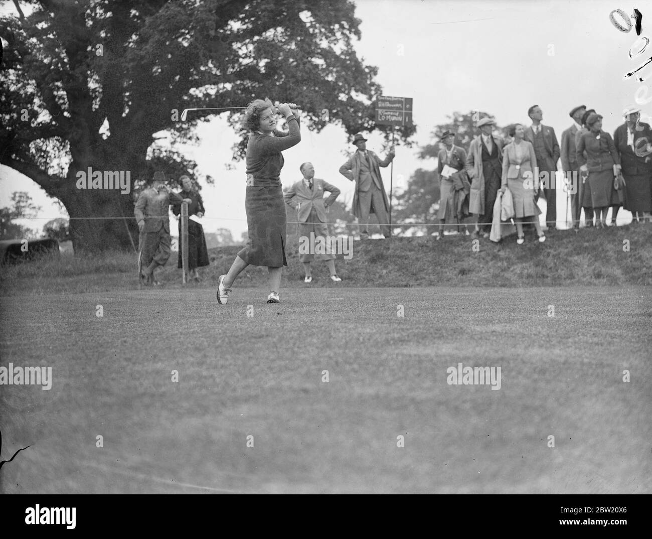 PAM Barton en voiture depuis le troisième tee. Elle joue avec A. H. Padgham contre R. Sweany et L. O. Munn dans l'un des foursomes du parcours de Moor Park. Ils jouent au match de Coronation des syndicats de golf anglais, dans lequel 20 amateurs de premier plan jouent contre 10 femmes golfeurs et 10 professionnels. Le concours se déroule au Moor Park Club, à Rickmansworth, et les débats seront consacrés au Fonds commémoratif national du Roi George V. 18 juin 1937 Banque D'Images