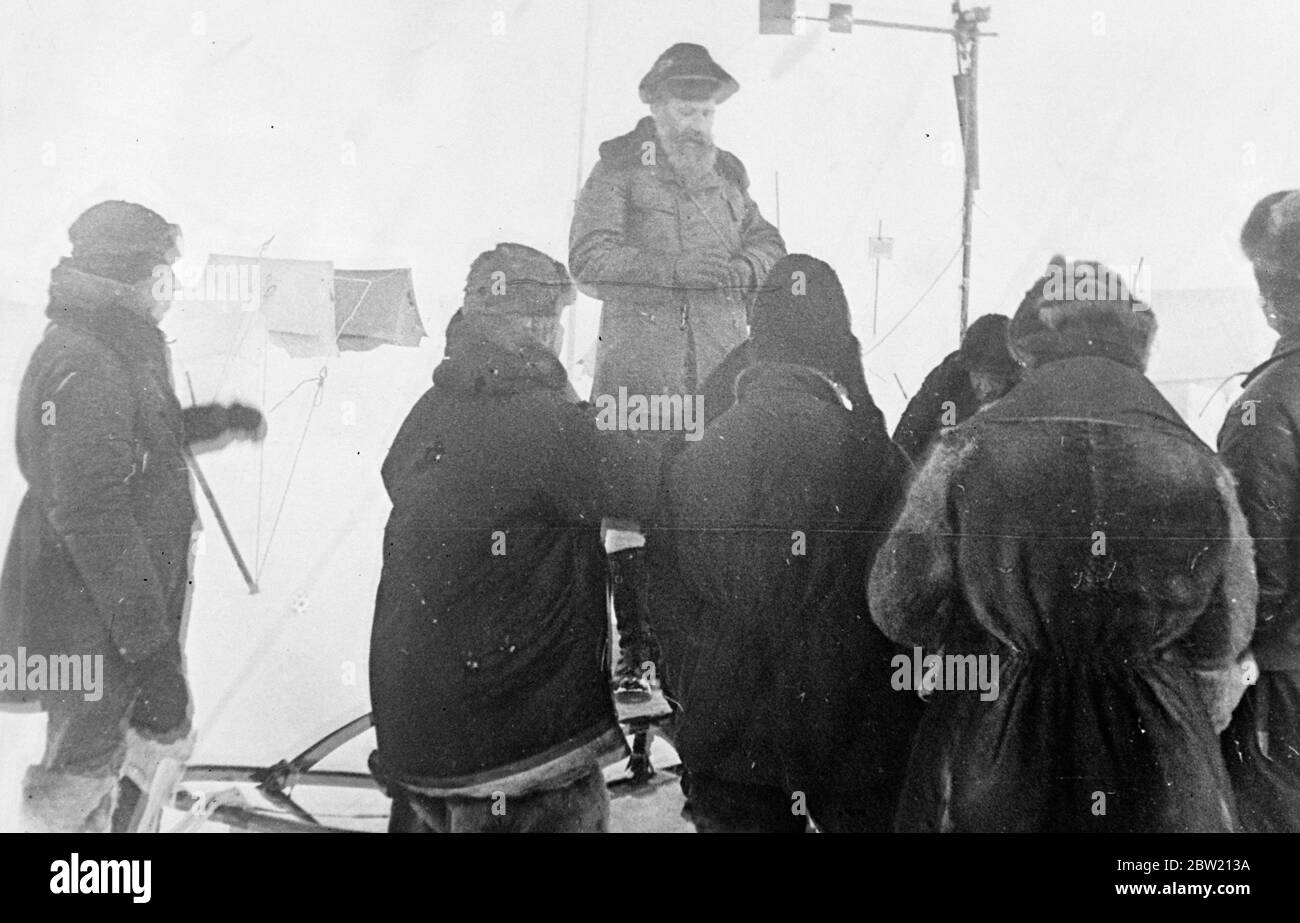 Le professeur Otto Schmidt, chef de l'expédition, donne des instructions aux membres de son parti de pionniers polaires soviétiques. Les scientifiques russes conquient la terre légendaire de glace et de neige au-dessus du monde qui est encore inexplorée. Ils se sont contenté d'un séjour d'un an sur une banquise au pôle Nord et font maintenant des enquêtes. 2 juillet 1937 Banque D'Images