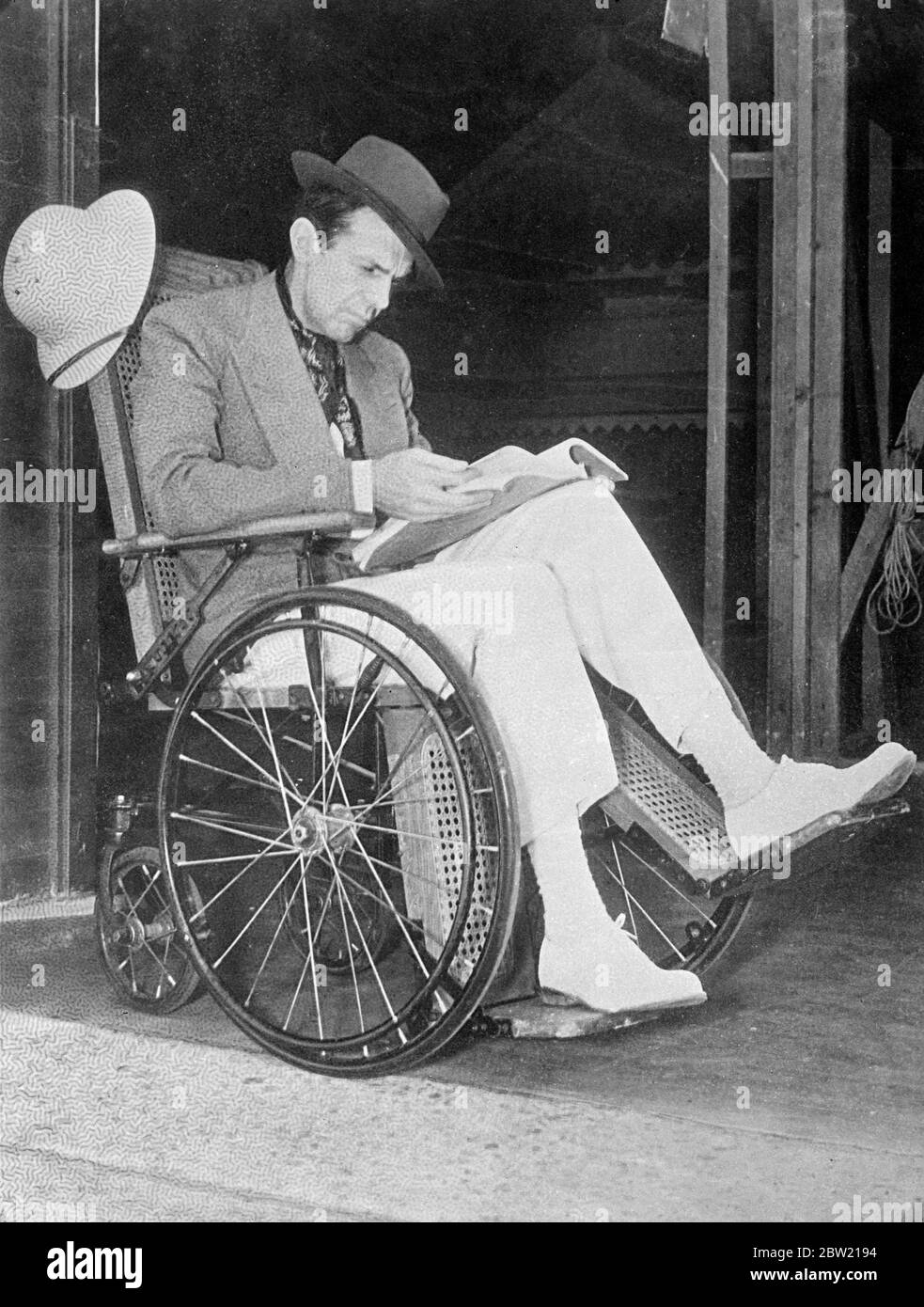 Raymond Massey, l'acteur britannique se remet des effets de la phlébite (caillot de sang dans la jambe) à Hollywood. Afin de perdre le plus peu de temps possible, M. Massey se déplace en fauteuil roulant sur les studios Samuel Goldwyn. 25 août 1937 Banque D'Images