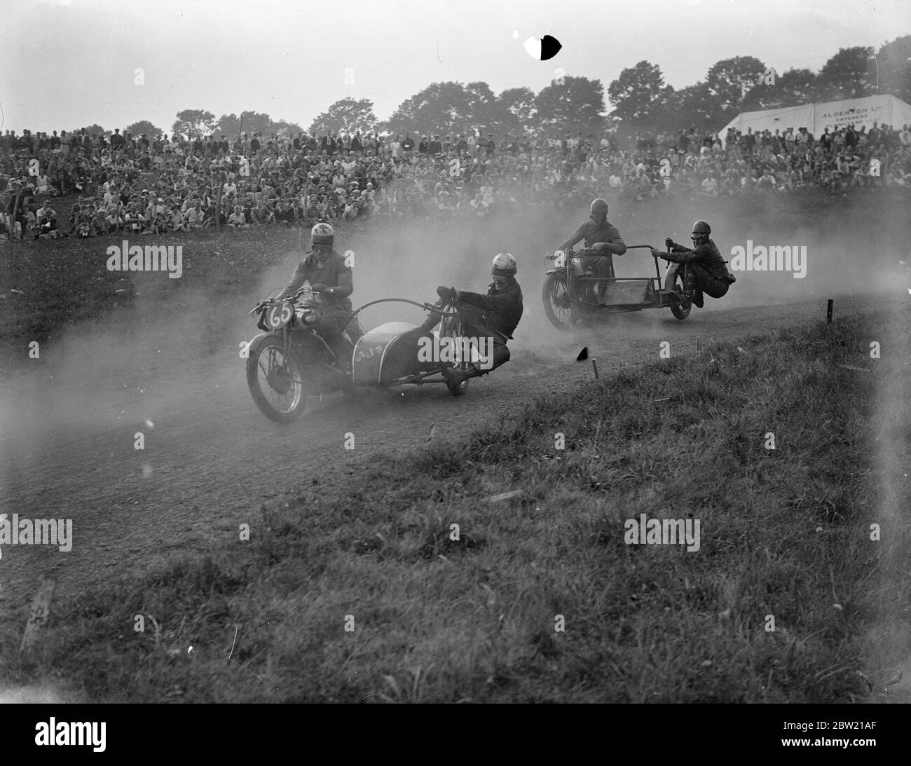 Nuages de poussière qui s'élève alors que W. Graham (AJS) a mené C. F. Smith (Norton) à l'angle de la course de 500 cc sidecar, lors de la réunion d'août du Sydenham Motor Club tenue à la Layham Grass Track, West Wickham, Kent 29 août 1937 Banque D'Images