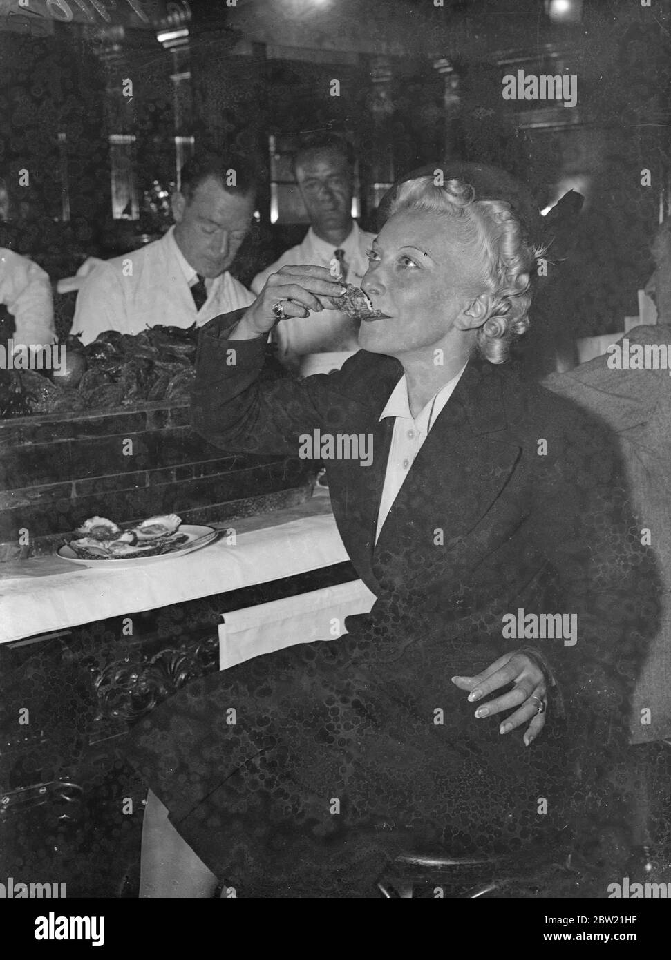 Annoncée par le retour du R au mois, la saison de l'huître s'est ouverte à Scott's, dans la rue Coventry, avec le rassemblement annuel de célébrités, y compris le marquis de Milford Haven, Miss Frances Day, l'actrice et experte en alimentation André Simone. Miss Frances Day en dégustant une huître. 1er septembre 1937 Banque D'Images