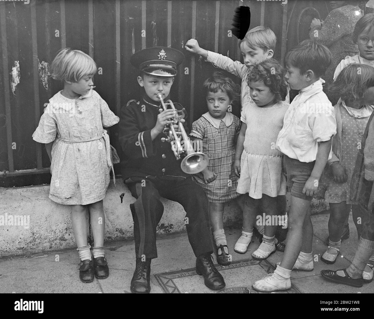 Bien qu'il n'ait que sept ans, Albert Hall est un joueur de cornet et il est un garçon aux ambitions. Albert joue le cornet dans le West London Silver Band et est considéré comme le plus jeune soliste du monde. C'est un Welshman. Albert jouant son cornet avant une jeune galerie admirative à sa maison Acton. 1er septembre 1937 Banque D'Images